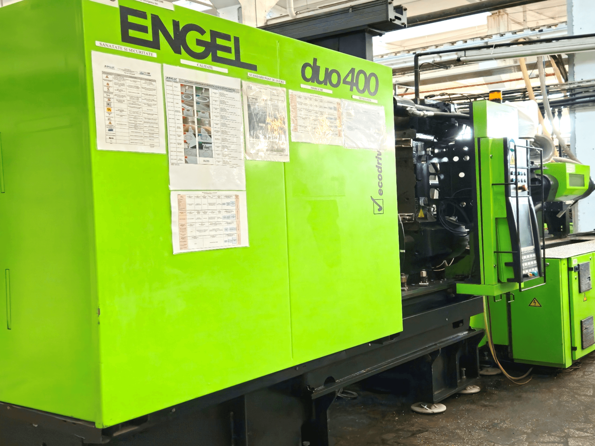 Zöld ENGEL duo 400 fröccsöntőgép, elölnézet, a vezérlőpanel és a biztonsági dokumentáció külső oldalán.