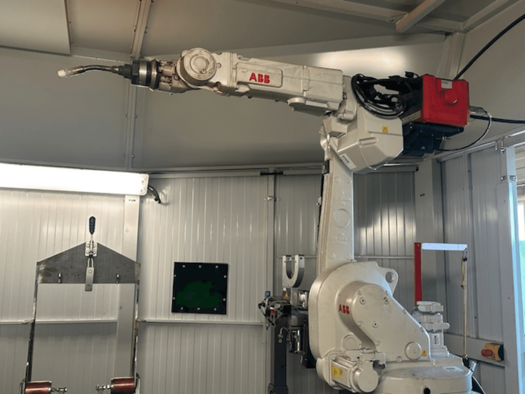 ABB Schweißroboter Flex Arc - a hegesztőszerszámmal ellátott robotkar oldalnézetben, olyan részleteket mutat be, mint a vezérlőpanel és a kábelek.
