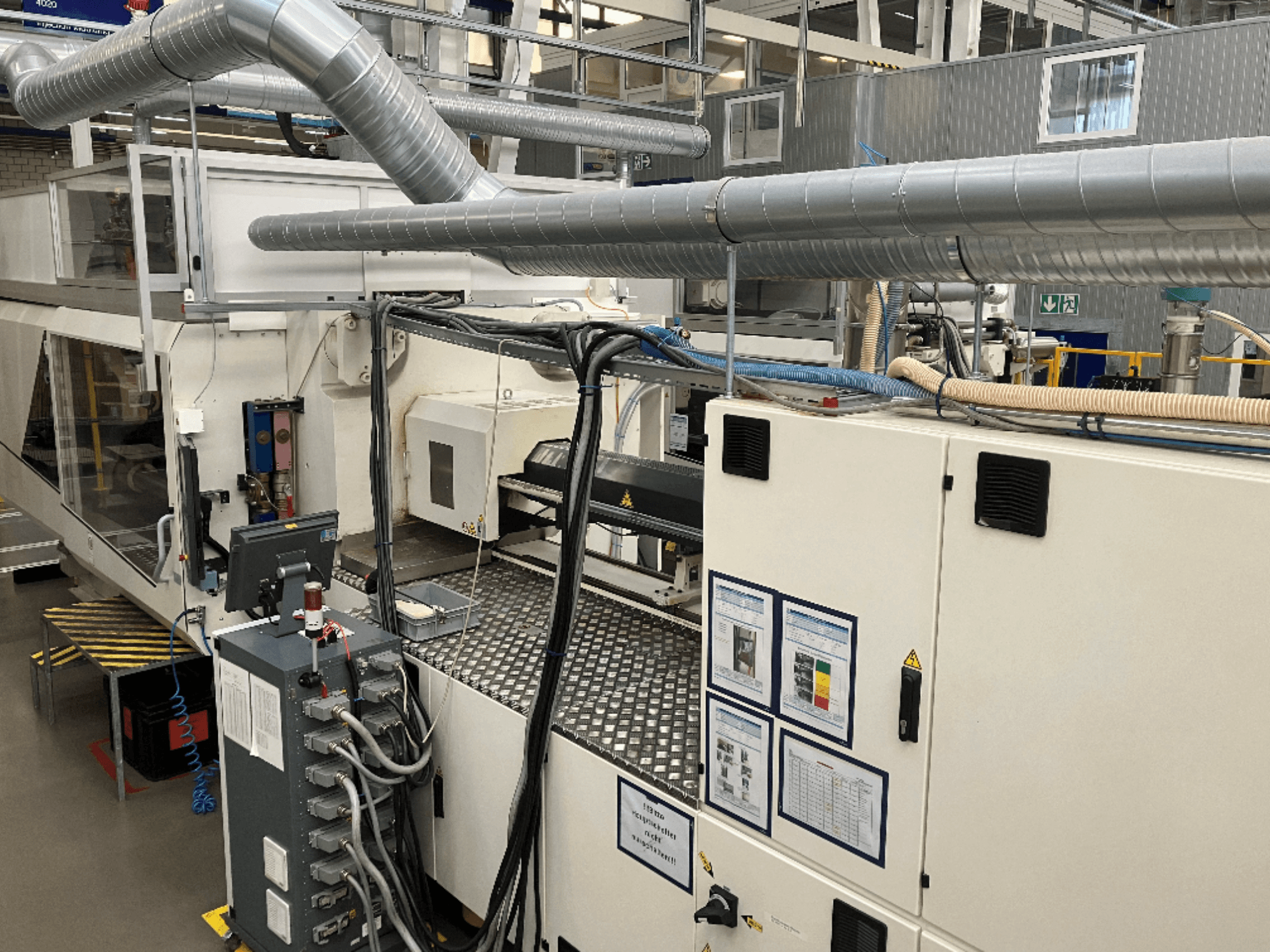 Ipari gépek kiterjedt csővezetékekkel, vezérlőpanelekkel és kezelési kézikönyvekkel, felülről lefelé nézve.