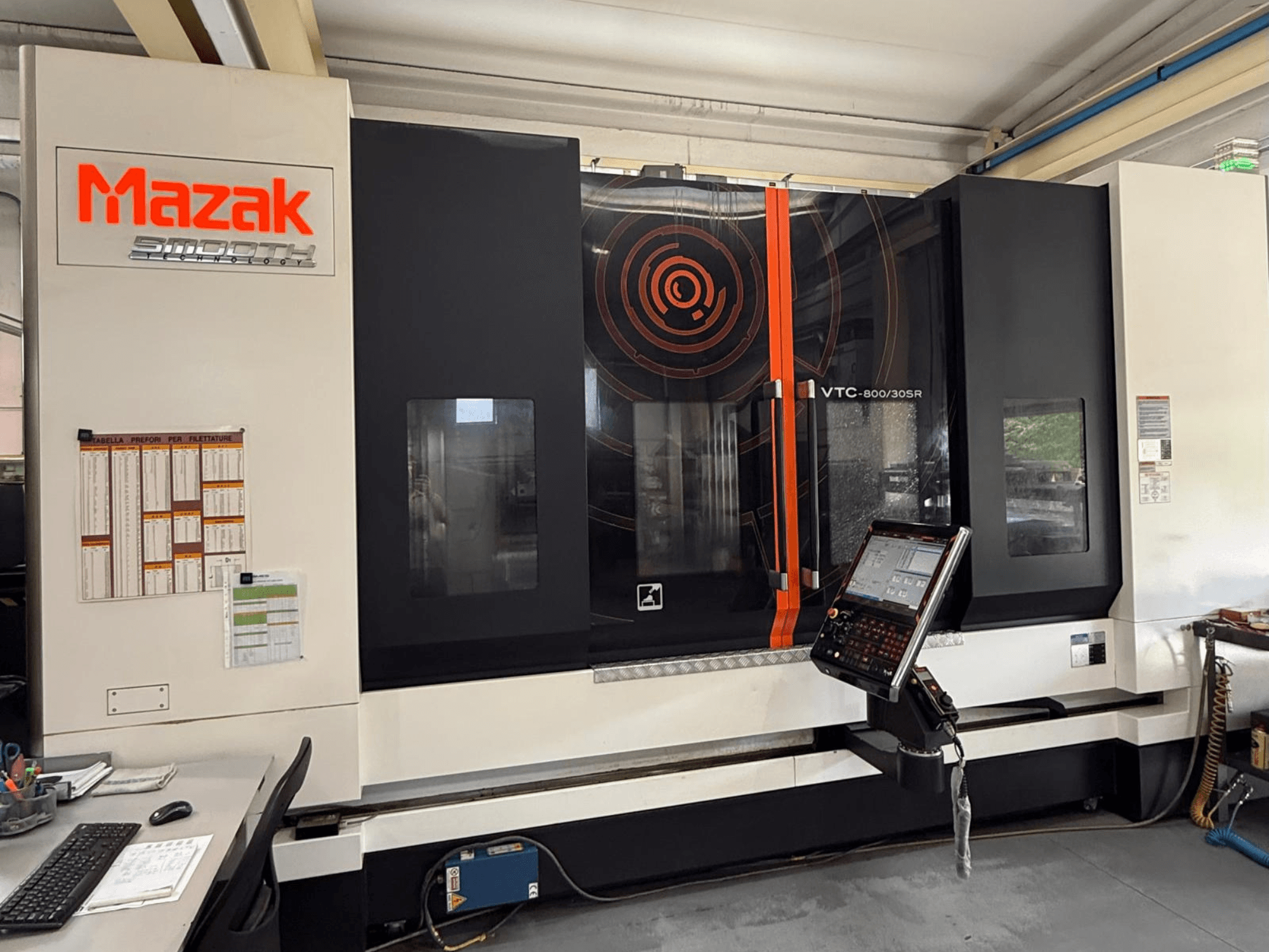 Mazak VTC-800/30SR függőleges megmunkáló központ, elölnézet, amelyen látható a vezérlőpanel, a kijelző és a munkaterület.