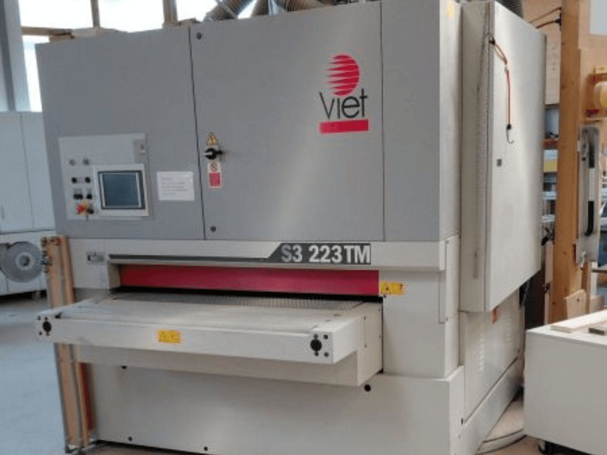 A VIET S3 223TM szalagcsiszoló elölnézetben, a kezelőpanellel, a csiszolóasztallal és a biztonsági címkékkel.