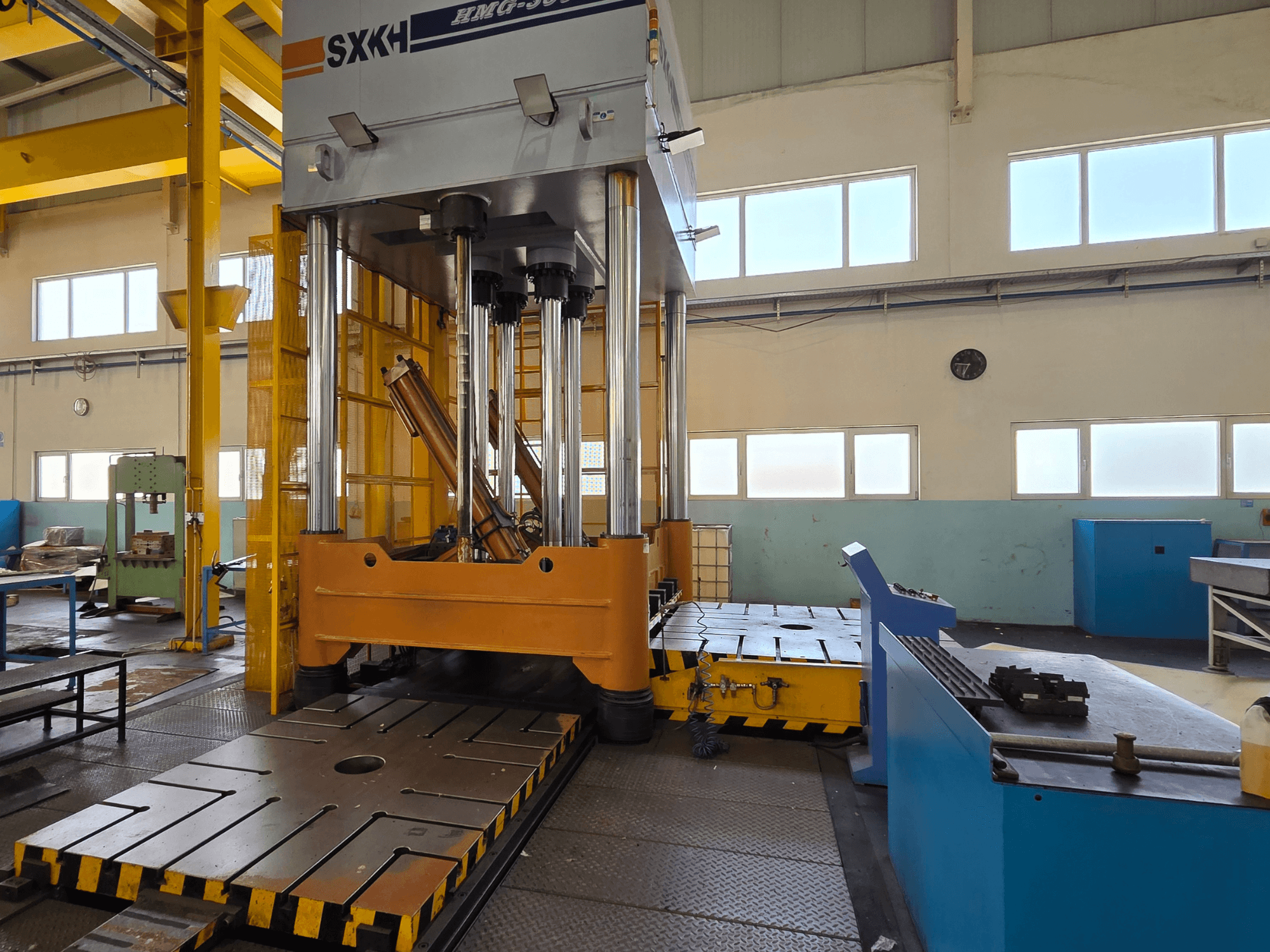 SXKH HMG-300JM hidraulikus prés elölnézetben, nagy préshengerekkel és robusztus talppal, gyári környezetben.