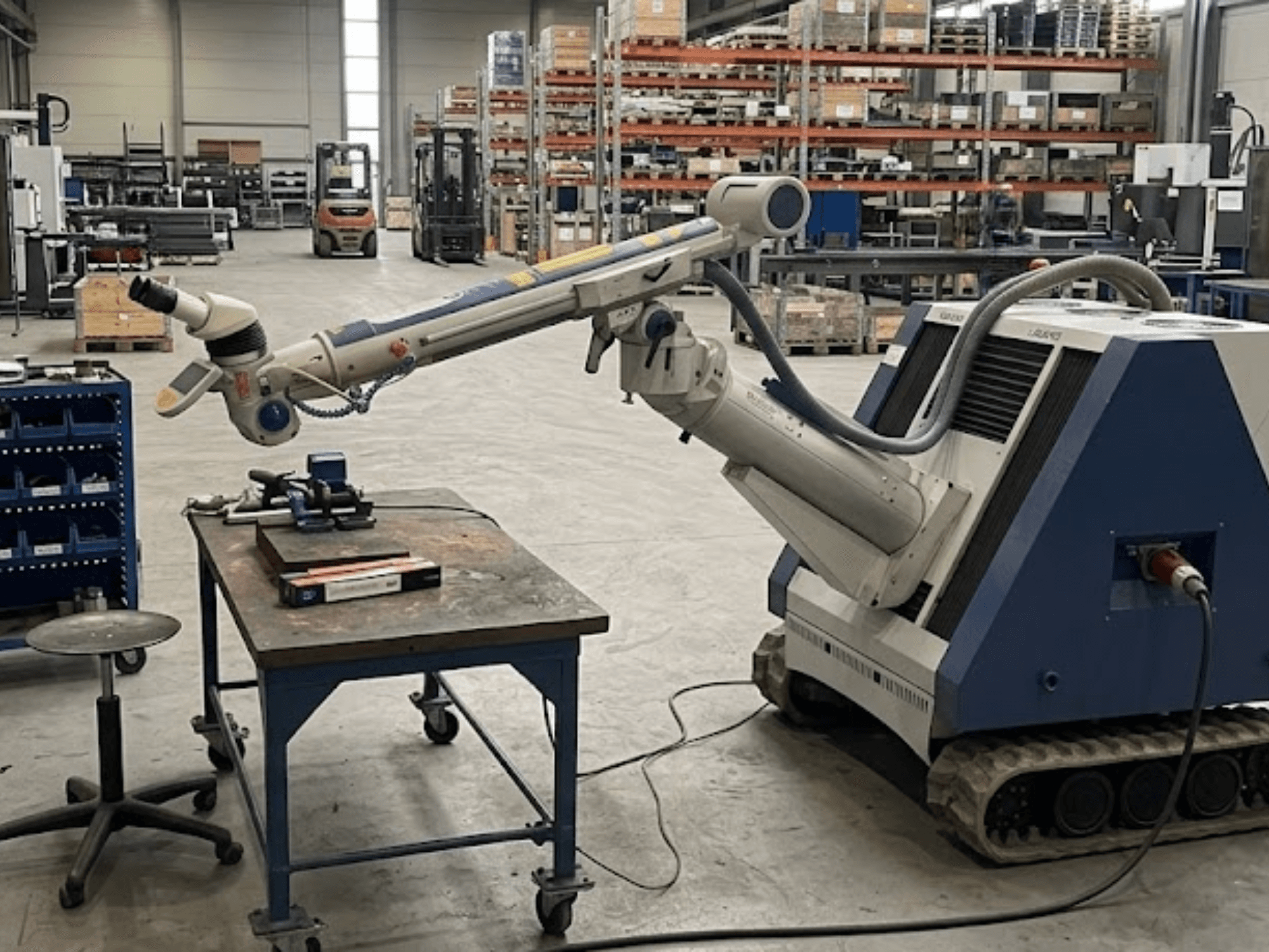 ALPHA LASER ALFlak300 M szerszámgép egy műhelyben, robotkarral; elölnézet, amelyen látható a munkasztalon végzett precíz beállítás.