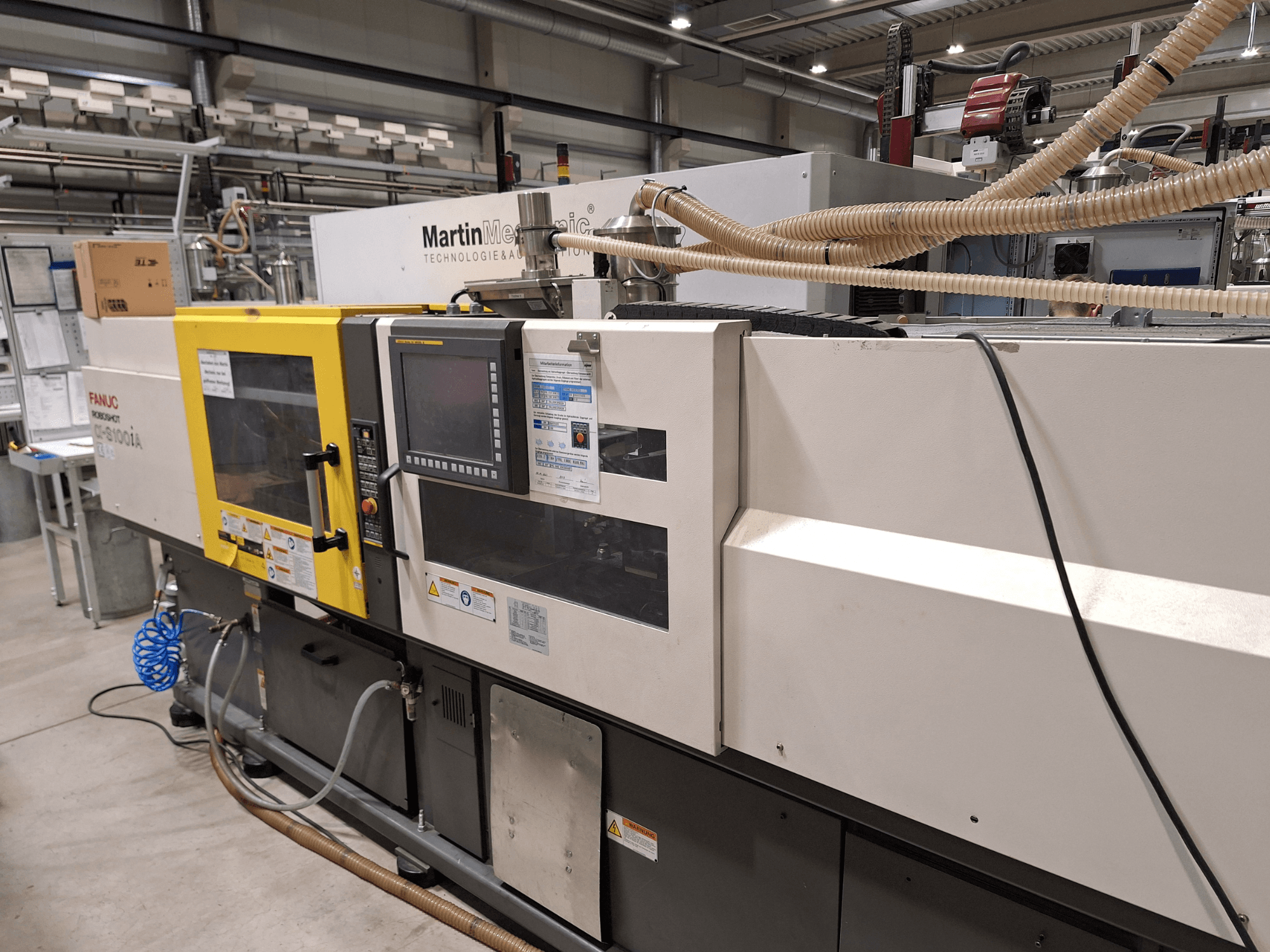 FANUC Roboshot S100iA elektromos fröccsöntőgép, oldalnézet, érintőképernyővel és biztonsági címkékkel felszerelve.