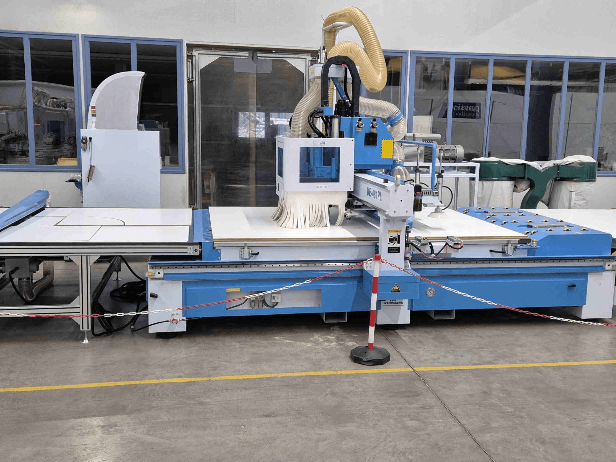Kék CNC router UE-621PL elölről, nagy vágóasztallal és csatlakoztatott porelszívó rendszerrel.