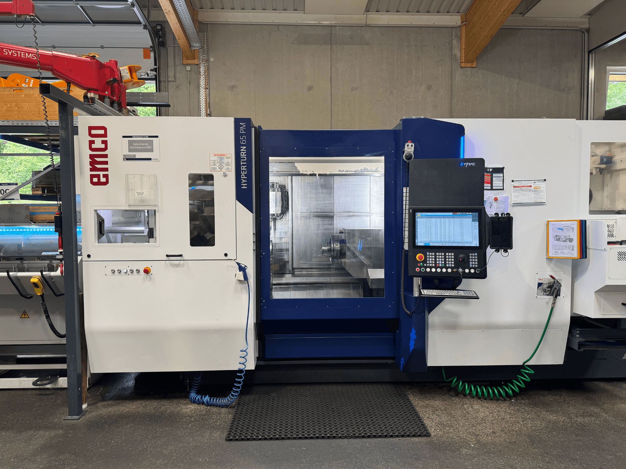 EMCO Hyperturn 65 PM gép, előlnézet, a vezérlőpanel, az orsó területe és a működési jellemzők megjelenítése.