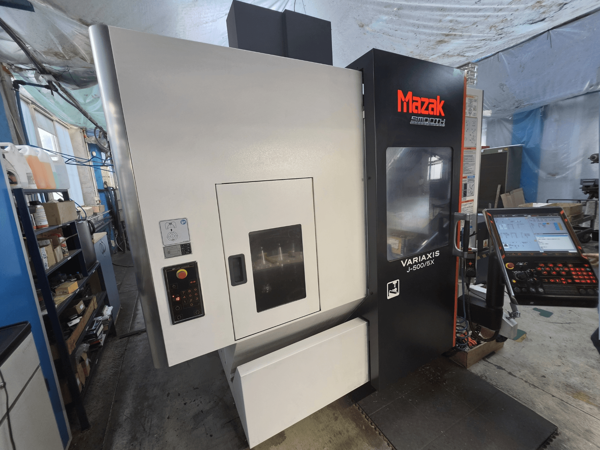 A Mazak VARIAXIS J-500/5X függőleges megmunkáló központ elölnézetben, vezérlőpanellel és nagy megmunkálóterület-ablakkal.