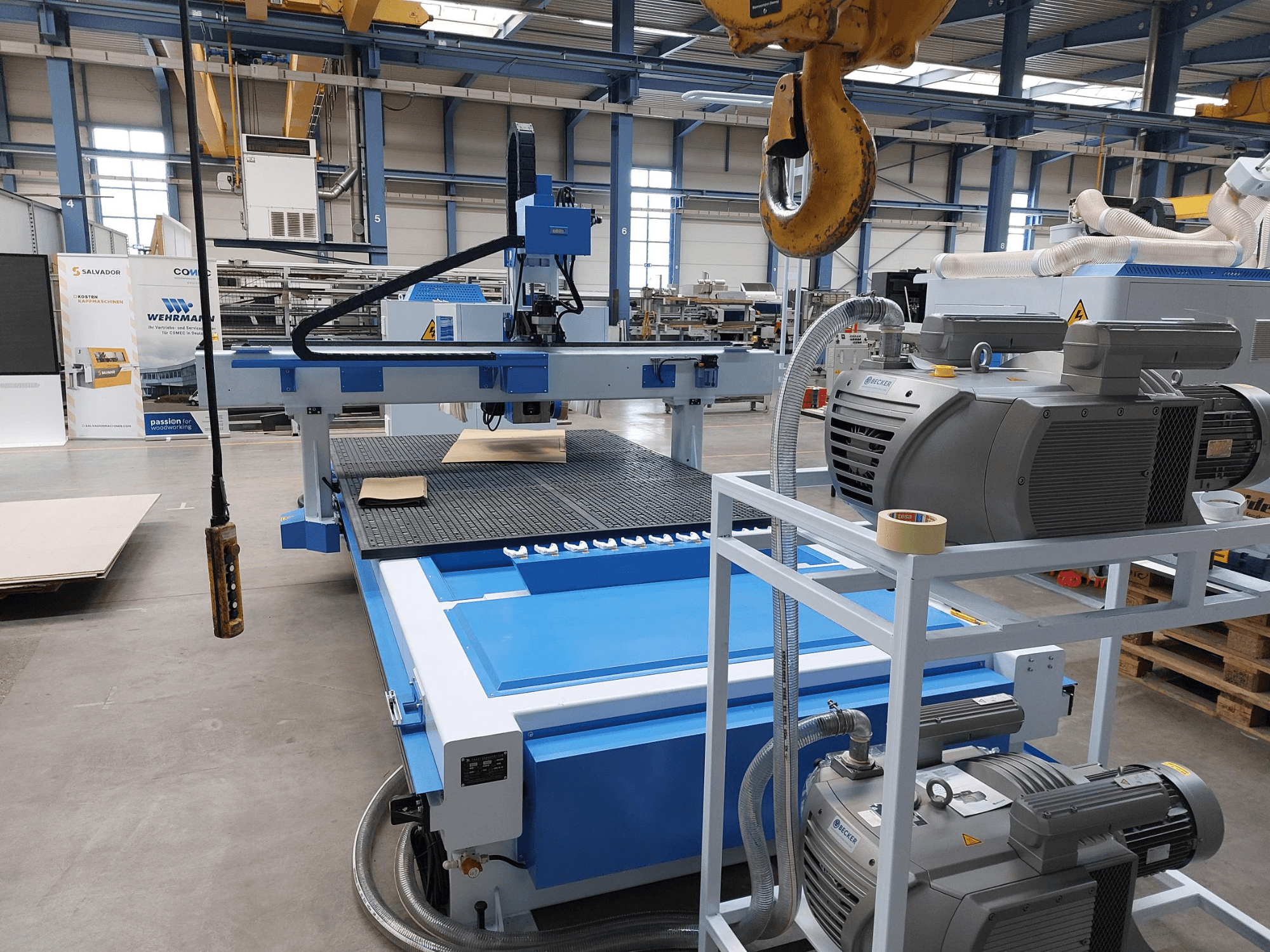 QUICK CNC UA 481 CNC faipari megmunkáló központ, elölnézet, amelyen látható a vezérlőpanel, a motorok és a munkalap egy fadarabbal.