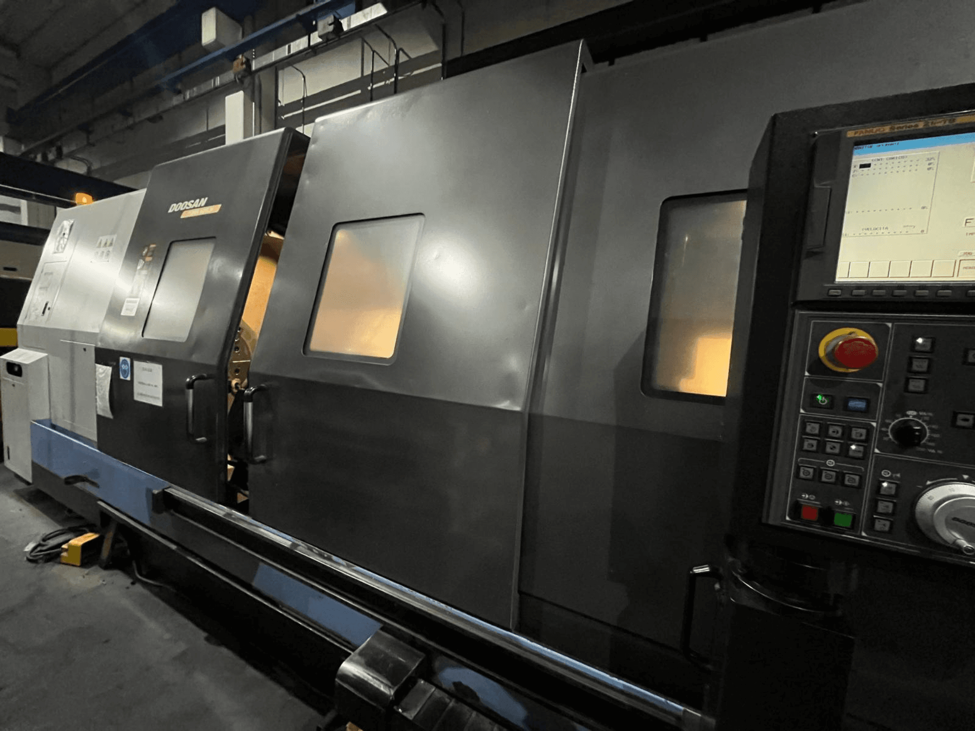 Doosan CNC esztergagép elölnézetben, a vezérlőpanel és a kezelőfelület látható digitális kijelzővel és gombokkal.