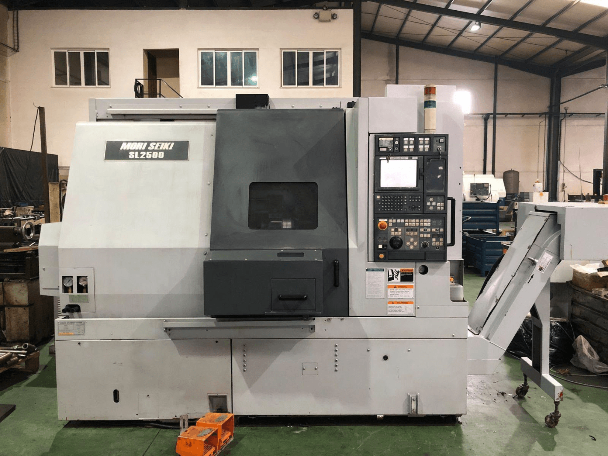 DMG Mori Seiki SL 2500 Y eszterga-marógép, oldalnézet, amelyen látható a vezérlőpanel és a forgácsszállító.