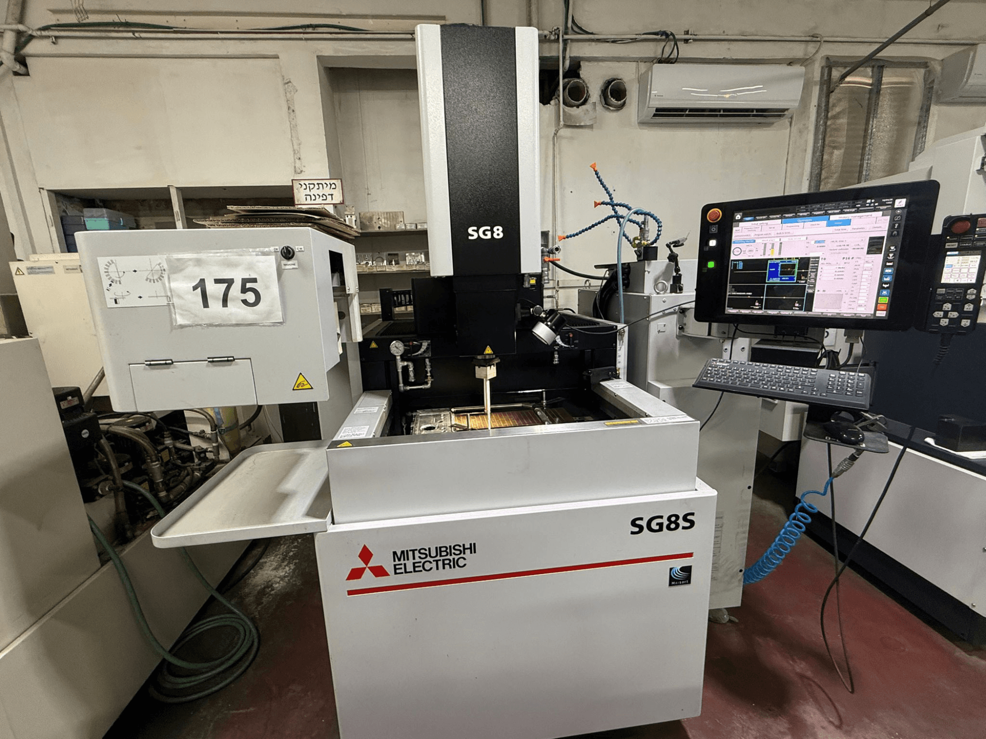 Mitsubishi SG8S süllyesztéses szerszámsüllyesztő gép, elölnézetben a monitor és a vezérlőpanel látható; a munkaterületen a szerszám beállítása látható.