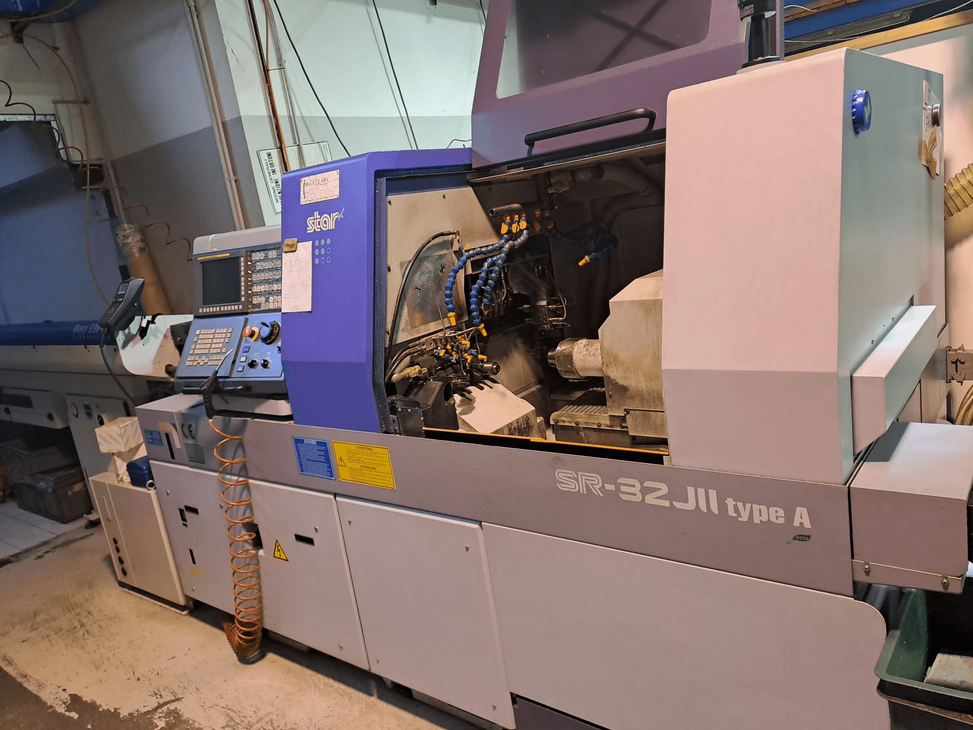 STAR MICRONICS SR-32JII-típusA svájci típusú esztergagép oldalnézetben, a vezérlőpanel és a látható megmunkáló alkatrészek.