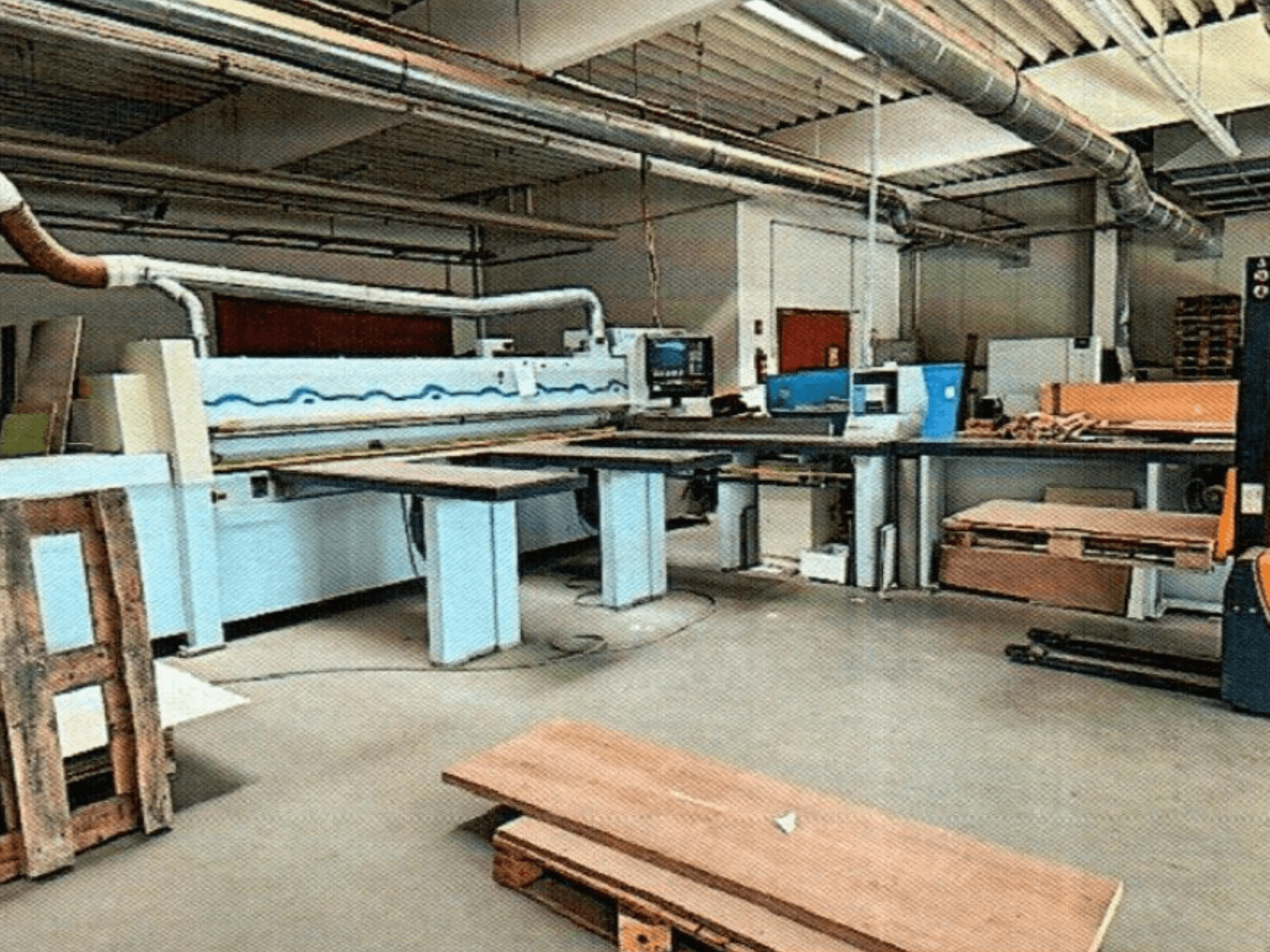 HOMAG HPL 11/38/22 lemezfűrész egy műhelyben, nagy vágóasztallal és bemutató konzollal, szemből nézve.