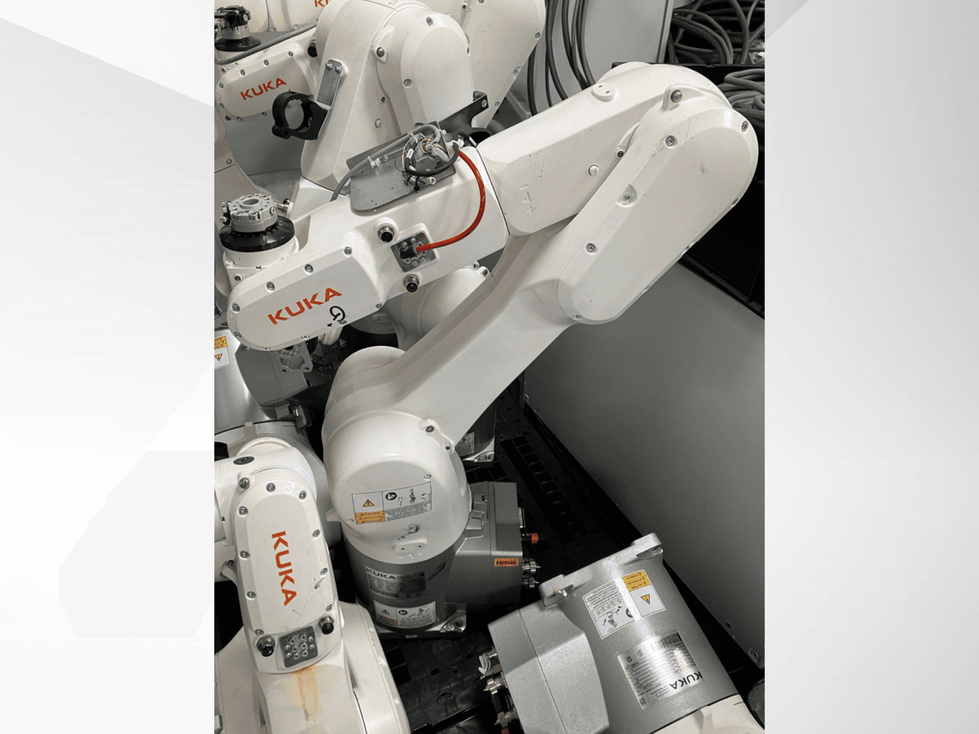 KUKA KR 6 R900 CR robotkar, oldalnézet; látható motorok és csatlakozók, feliratozott biztonsági figyelmeztetések és mechanikus karok.