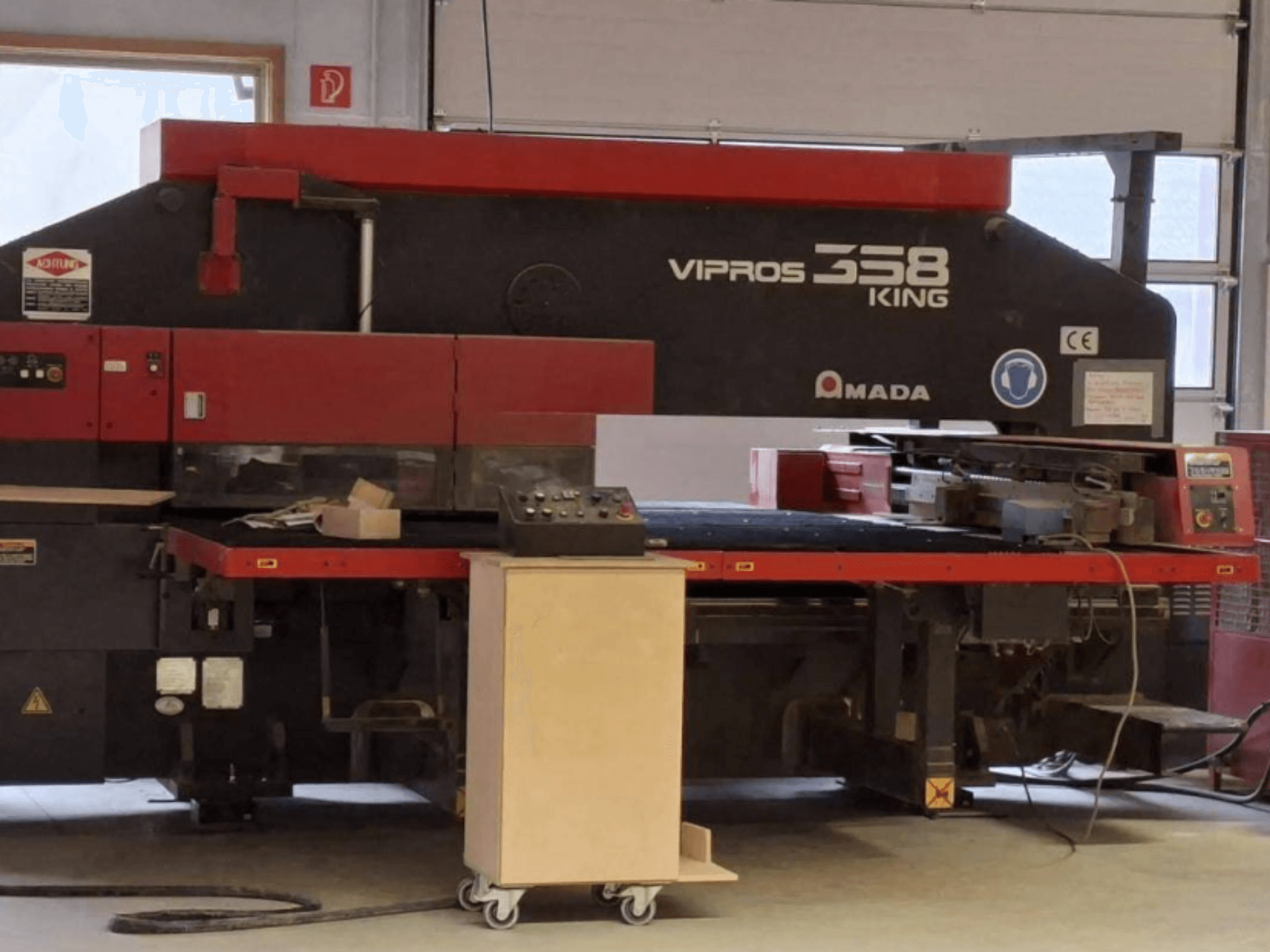Az AMADA VIPROS 358 KING CNC lyukasztógép oldalnézete, a vezérlőpanellel és a szerszámtárolóval.
