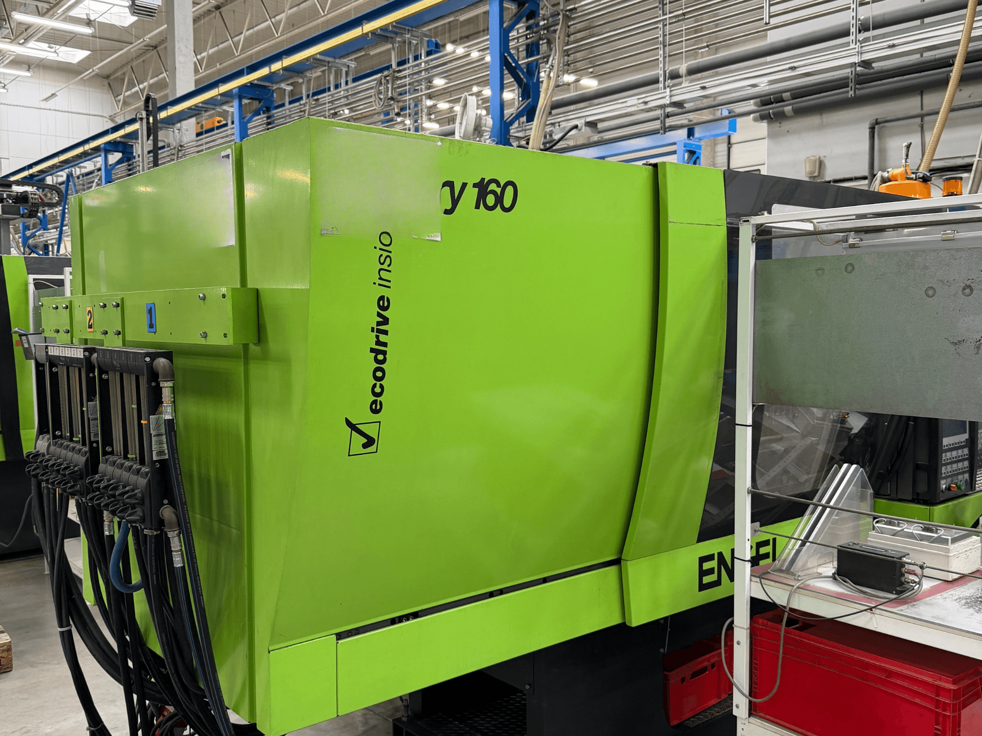 Zöld színű Engel Victory 500/160 tech hidraulikus fröccsöntőgép, oldalnézet, amelyen látható a vezérlőpanel és az Ecodrive funkció.