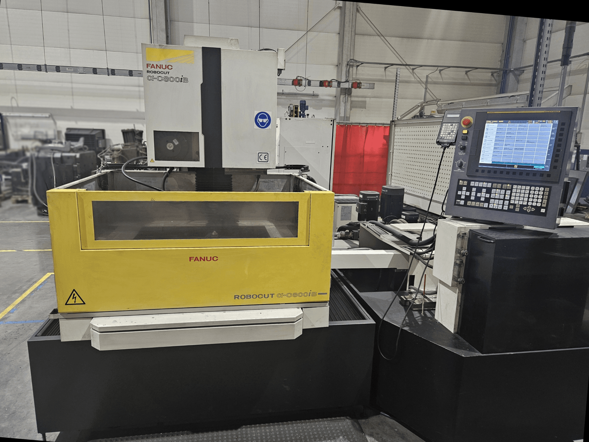 A FANUC Robocut α-C600iB előlapja sárga és szürke géptesttel, CNC vezérlőpanellel és működési kijelzővel.