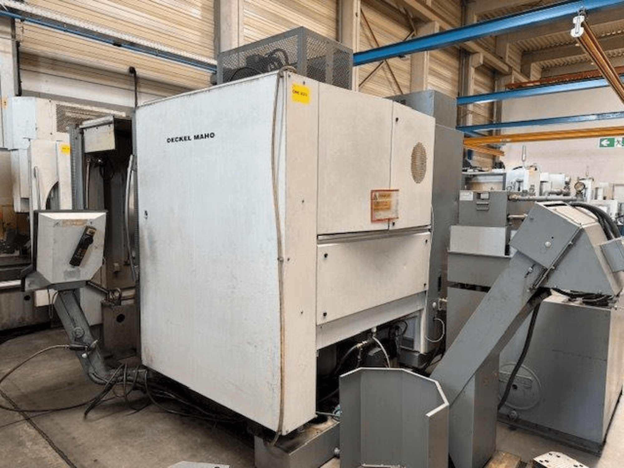 DECKEL MAHO DMC 100 V függőleges megmunkálóközpont, oldalnézet a kezelőpanellel és a különböző tartozékokkal.