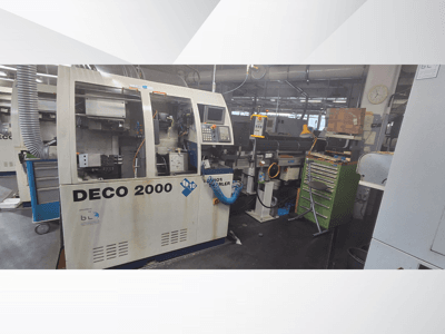 DECO 2000 gép elölről nézve, a vezérlőpanel, a csövek, valamint a szerszámokkal és dobozokkal zsúfolt munkaterület.