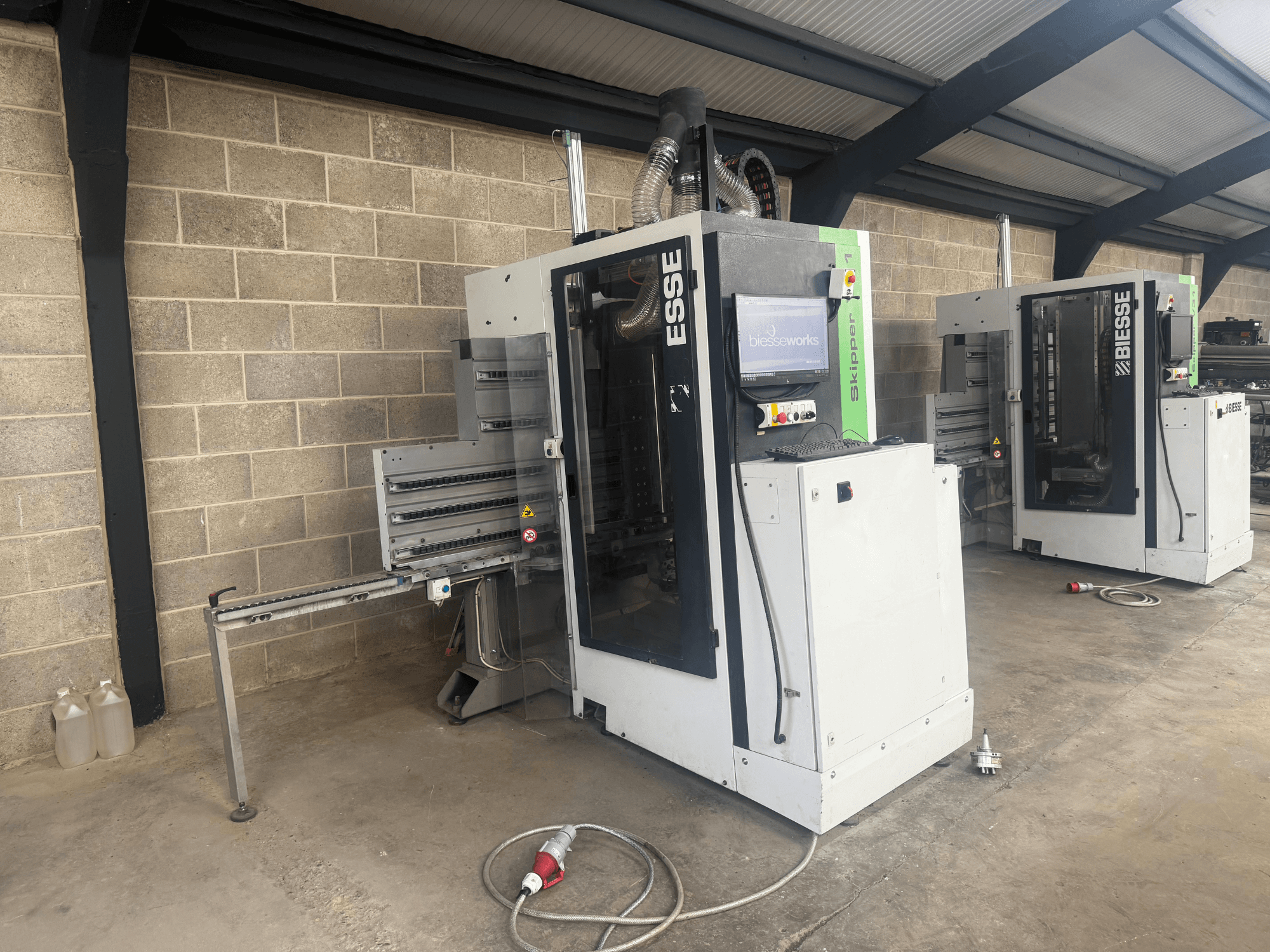 BIESSE Skipper v31 fafúrógép oldalnézetben, vezérlőpanel és a szomszédos gépek, műhelyben.