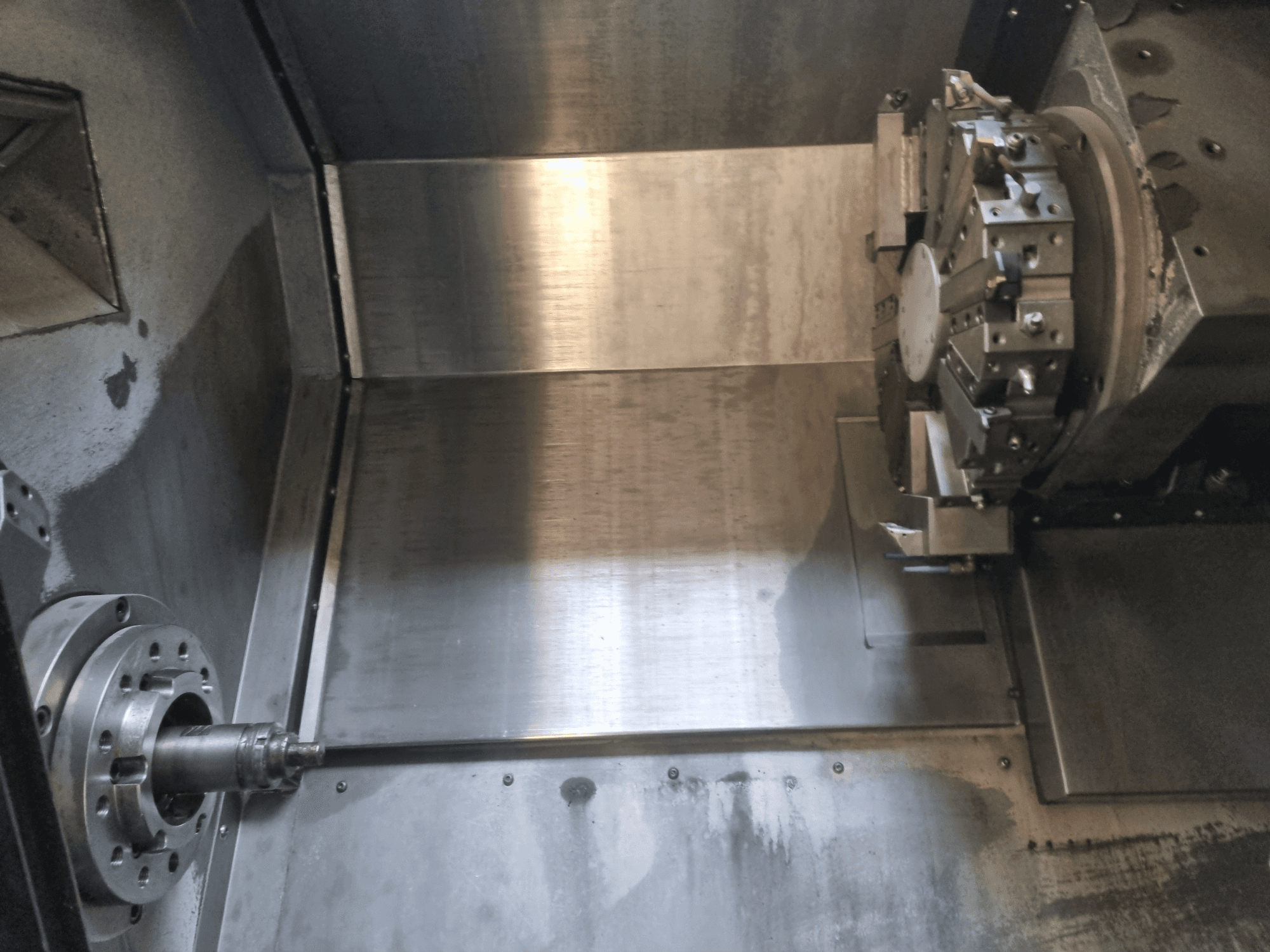 Egy CNC eszterga belső nézete, forgó orsóval és fém munkafelülettel, ipari precíziós mérnöki munkát bemutatva.