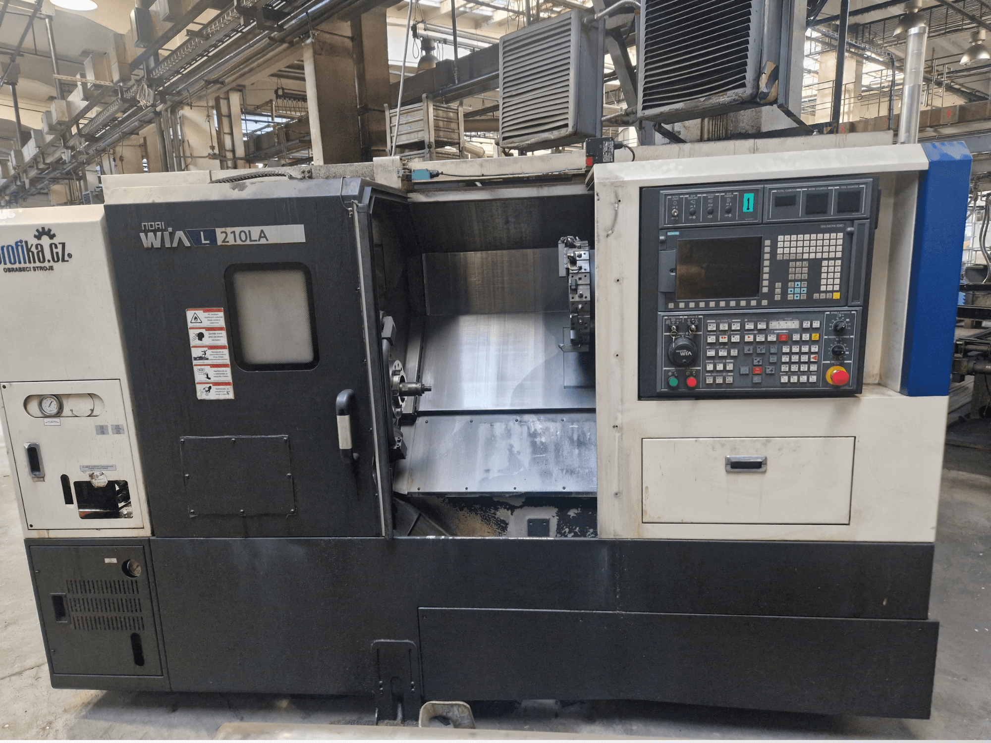 WIA L210LA CNC esztergagép, előlnézet, gombokkal, kijelzővel és látható megmunkálási területtel ellátott kezelőpanel.