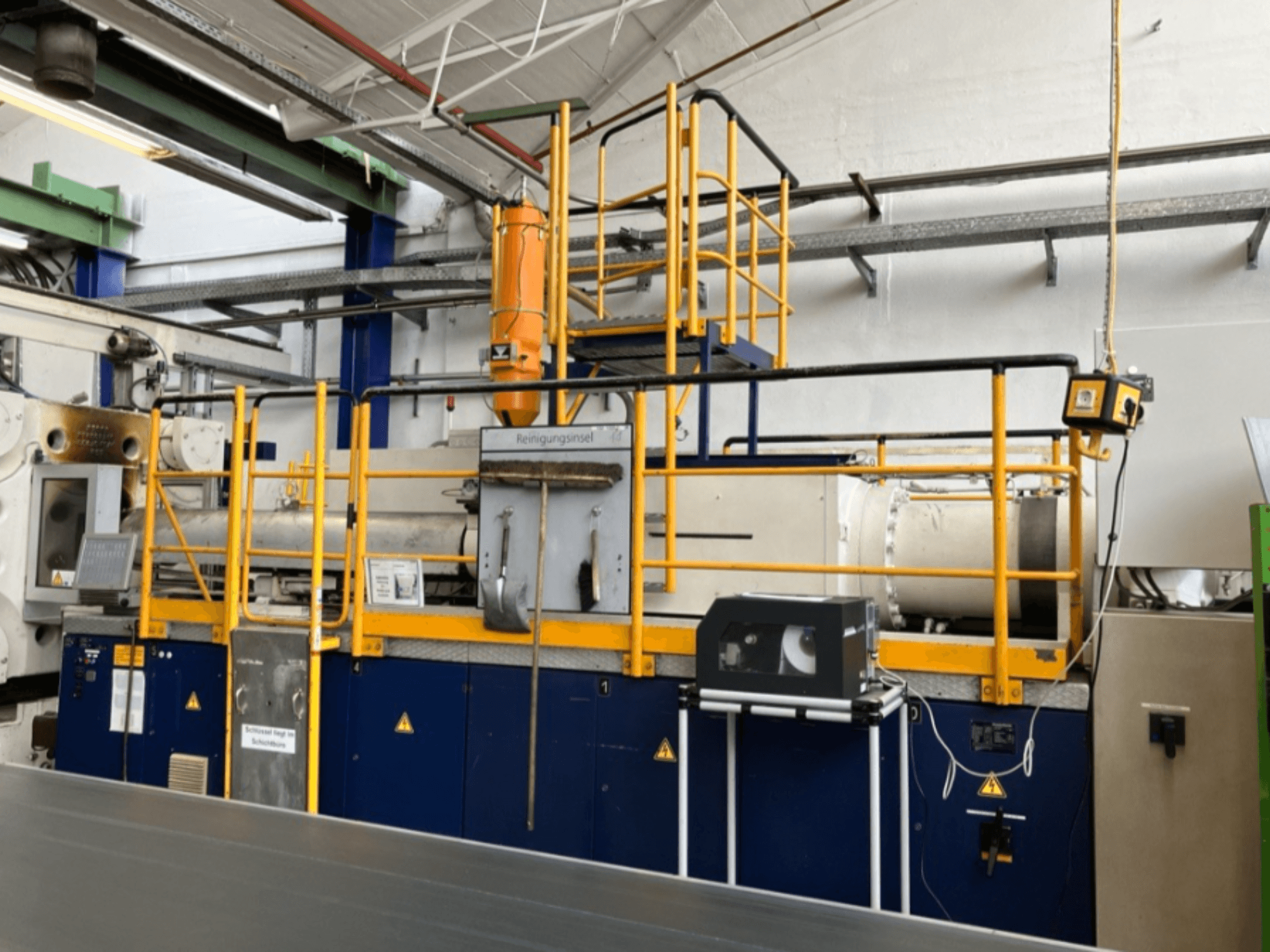 Krauss Maffei 1000-8000 M hidraulikus fröccsöntőgép, oldalnézet a biztonsági korláttal és a kezelőpanellel.