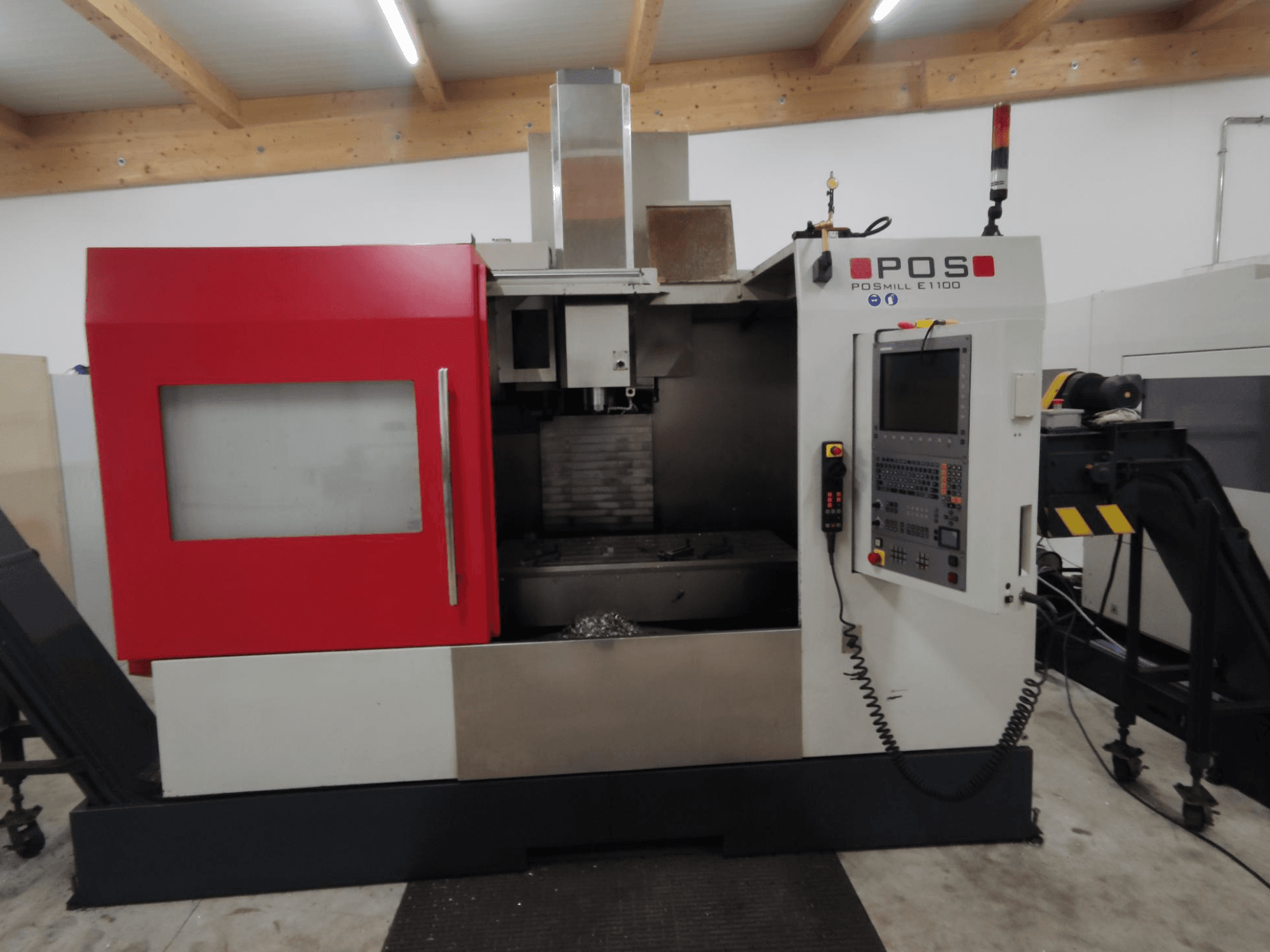 POS POS POSMILL E1100 CNC marógép elölnézetben, piros burkolattal, vezérlőpanellel és biztonsági lámpával a tetején.