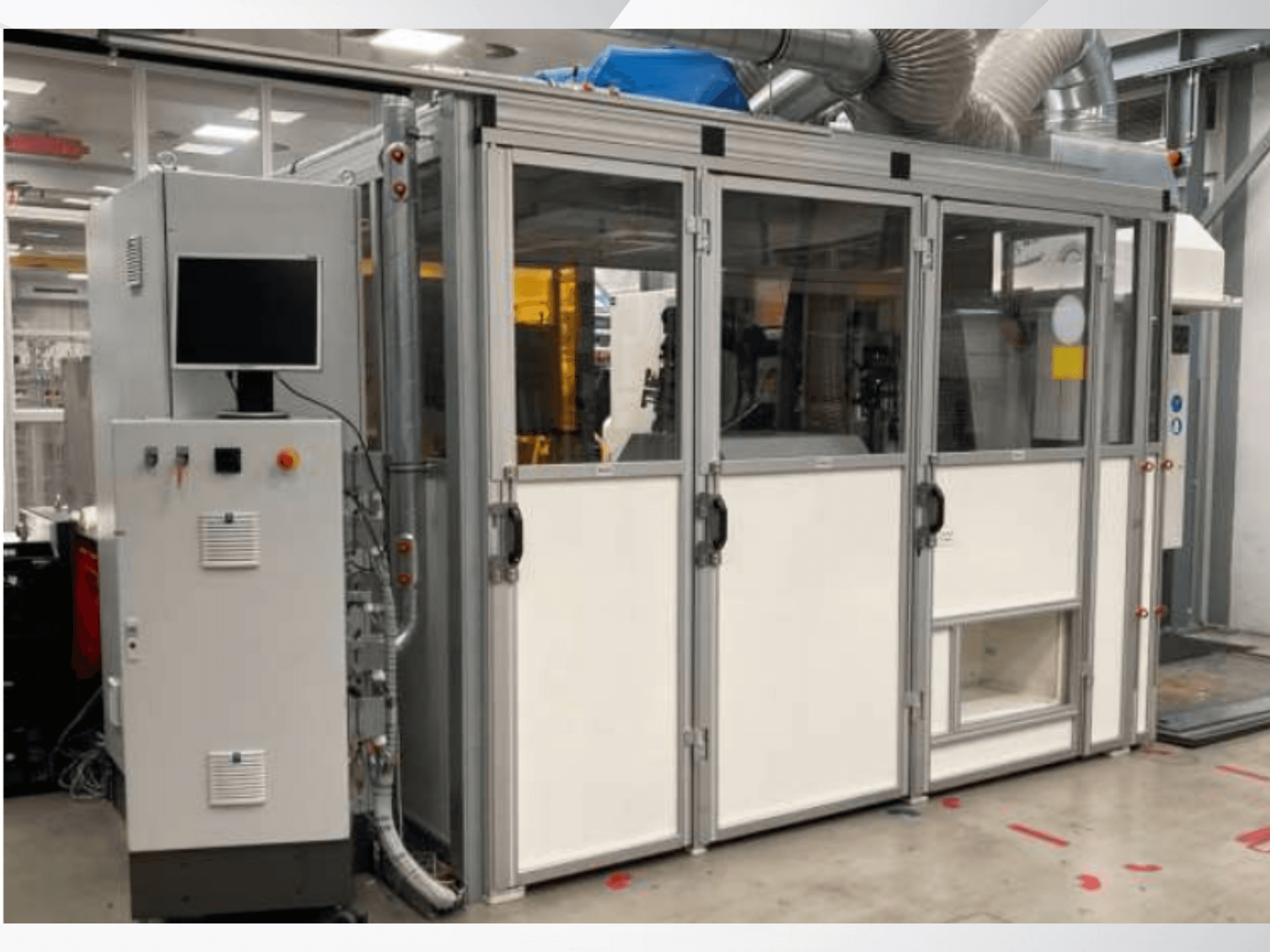 Ipari gép vezérlőpanellel, elölnézetben; üvegajtókkal, szellőzőcsatornákkal és látható vezetékekkel.