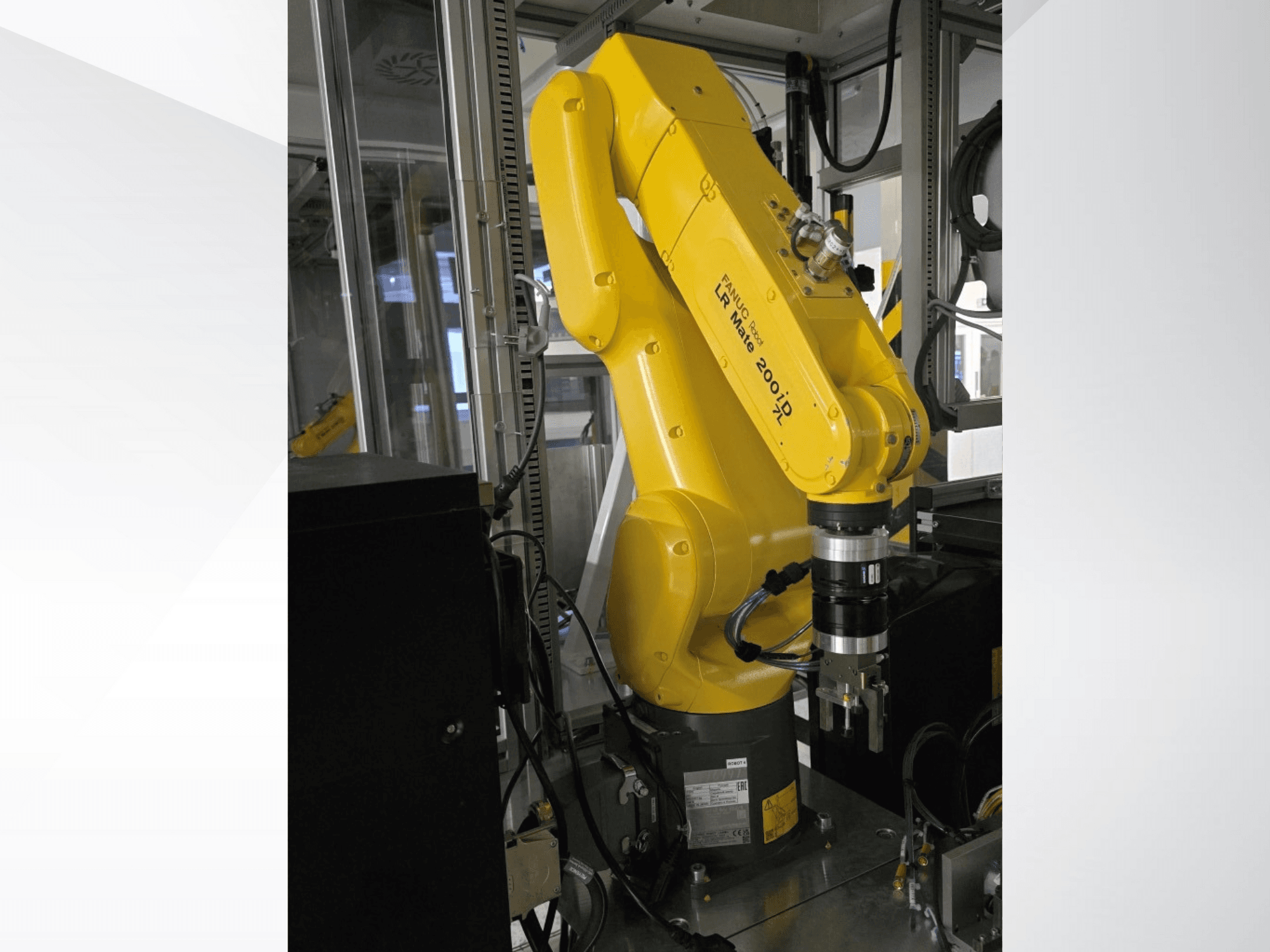 Sárga Fanuc LR Mate 200iD robotkar oldalnézetből, markolóval és különböző csatlakoztatott kábelekkel.