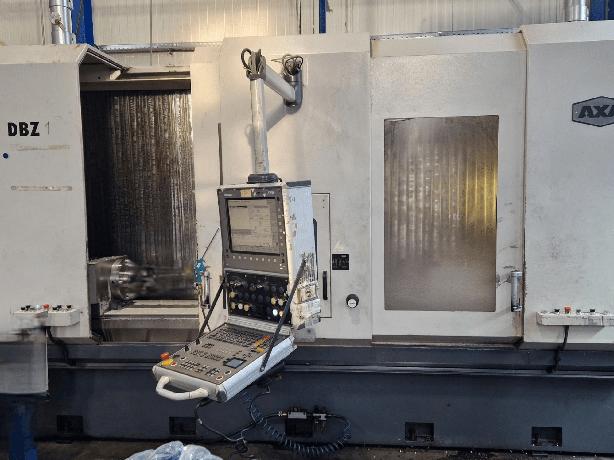 AXA DBZ függőleges megmunkálóközpont szögletes elülső nézetből, a vezérlőpanel és a látható vágószerszám területével.