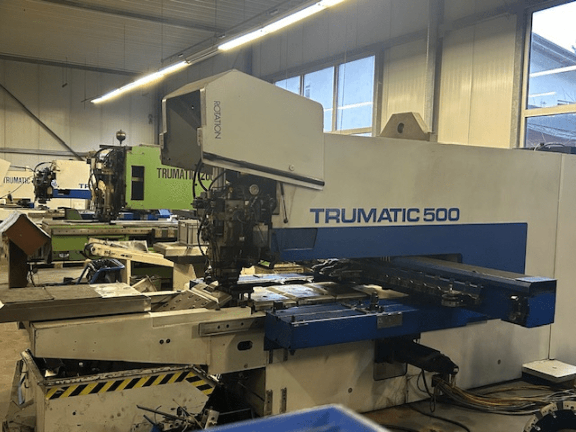 TRUMPF TRUMATIC 500 CNC lyukasztógép, elölnézetben, a vezérlőpanel és a mechanikus alkatrészek. Ipari műhelykörnyezet.