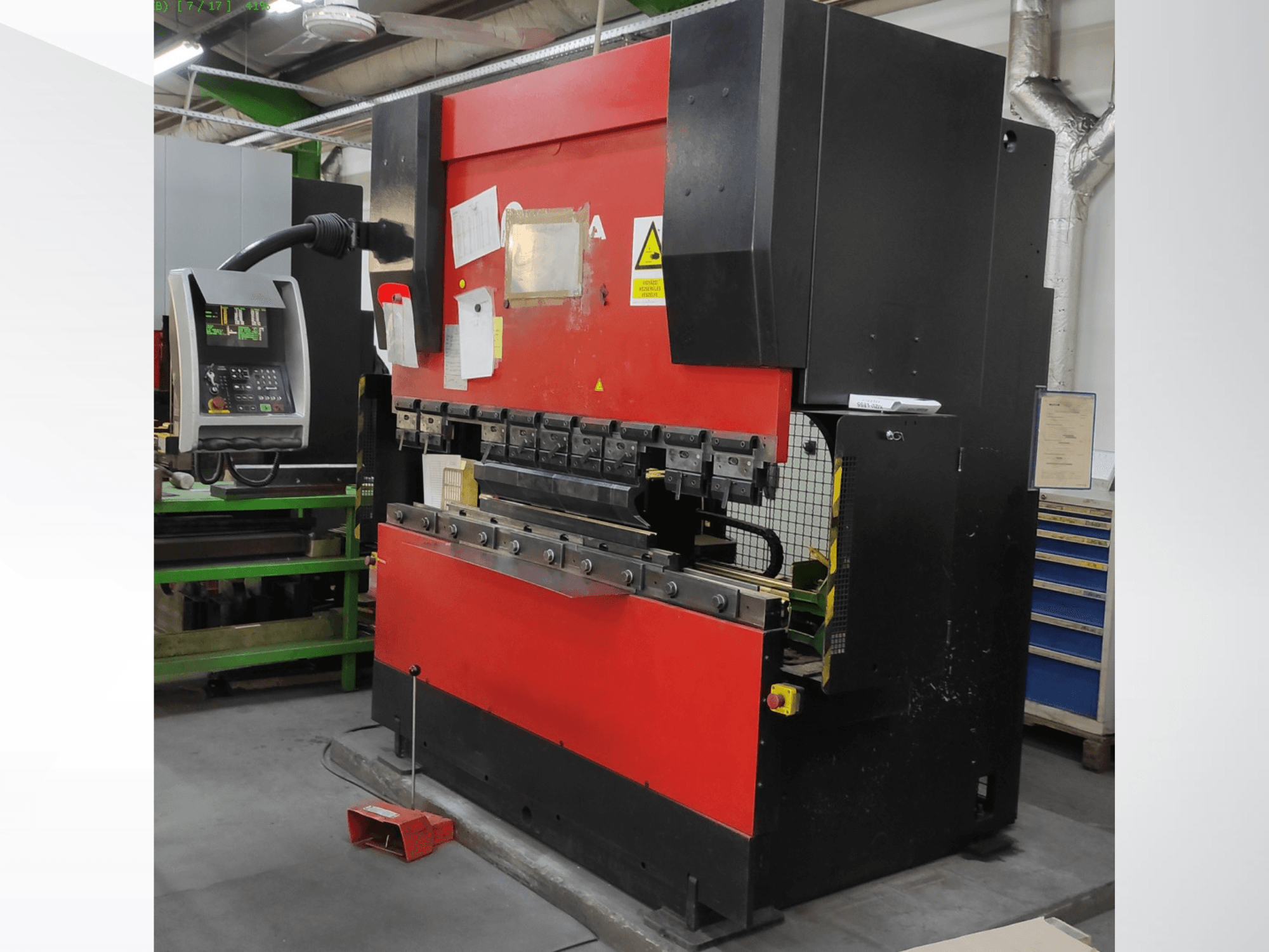 AMADA HFB 5020 présfék piros-fekete színben, elölnézetben, a kezelőpanel, a hajlítószerszámok és a biztonsági berendezések láthatóak.