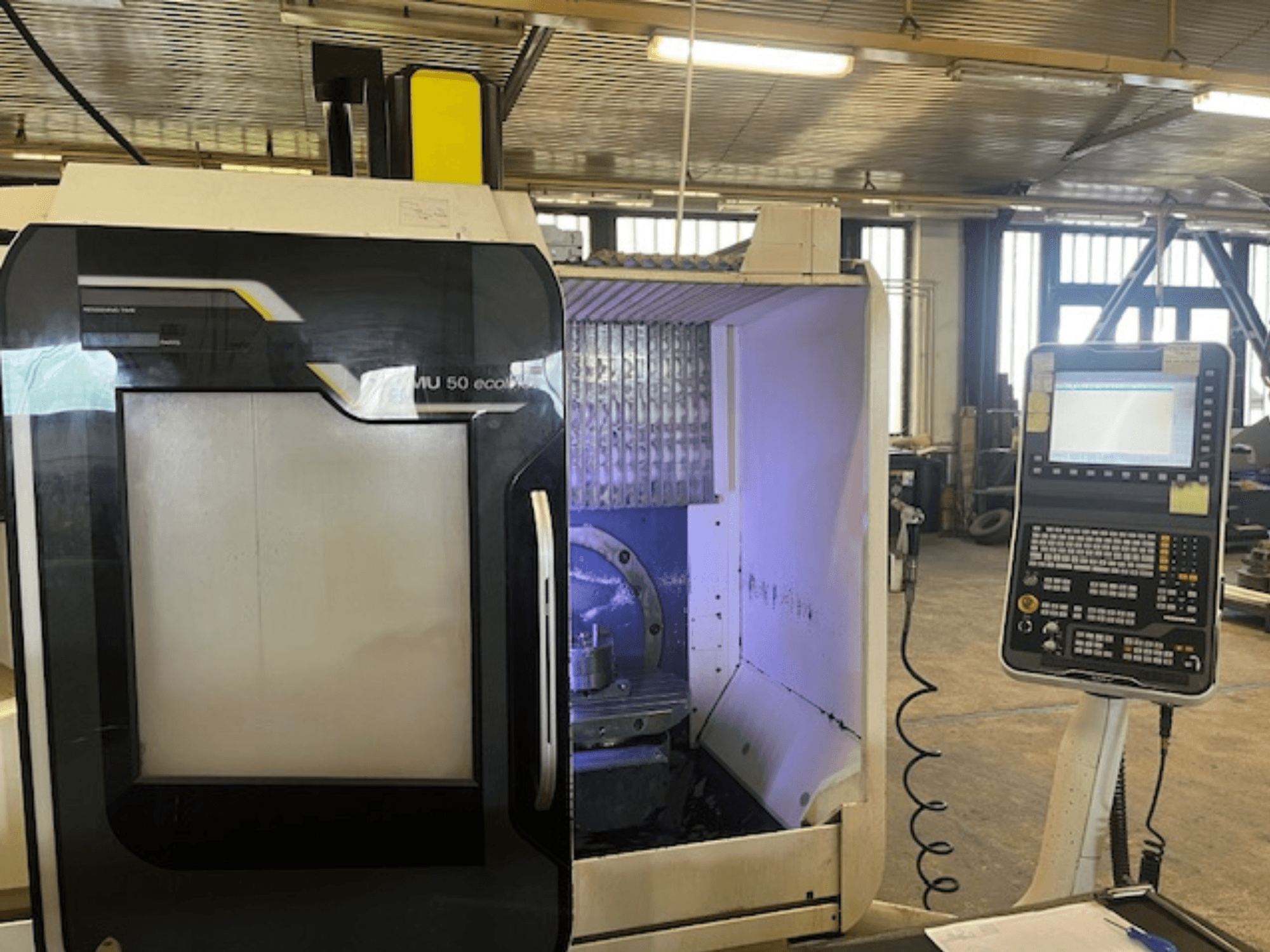 DMU 50 eco marógép előlapja a vezérlőpanellel, a szerszámtartó és a munkaterület megjelenítésével.