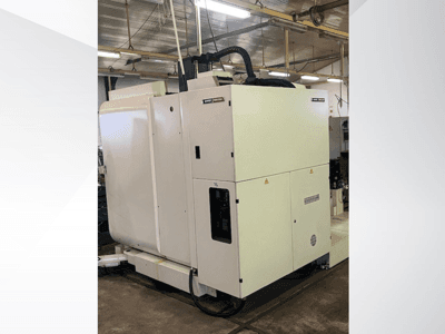 Fehér ipari CNC-gép szemből nézve, vezérlőpanellel és szellőztetéssel, műhelyben.