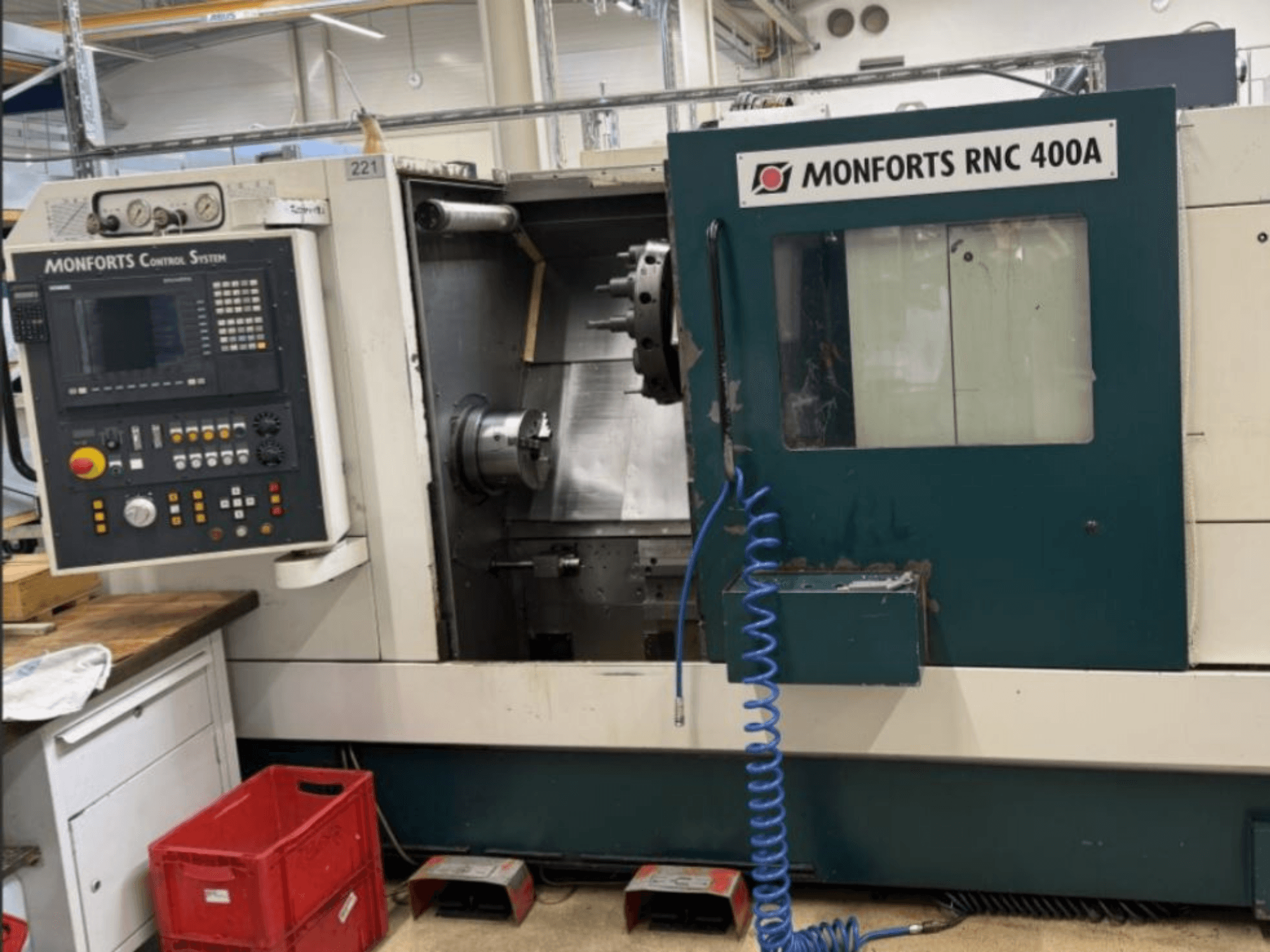 Monforts RNC 400 A vízszintes esztergagép, előlnézet, a vezérlőpanel és a munkaterület bemutatása kiemelt funkciókkal.