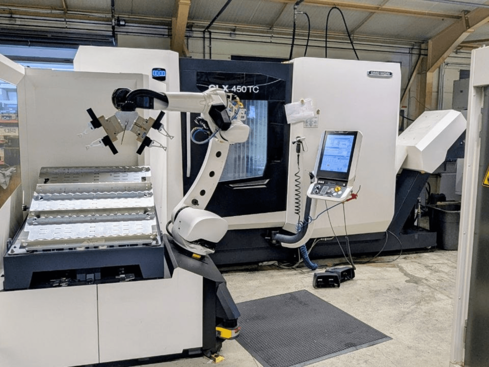 DMG MORI CLX 450 TC Robo2go-val, elölnézetből, a gép mellett látható a robotkar és a vezérlőpanel.