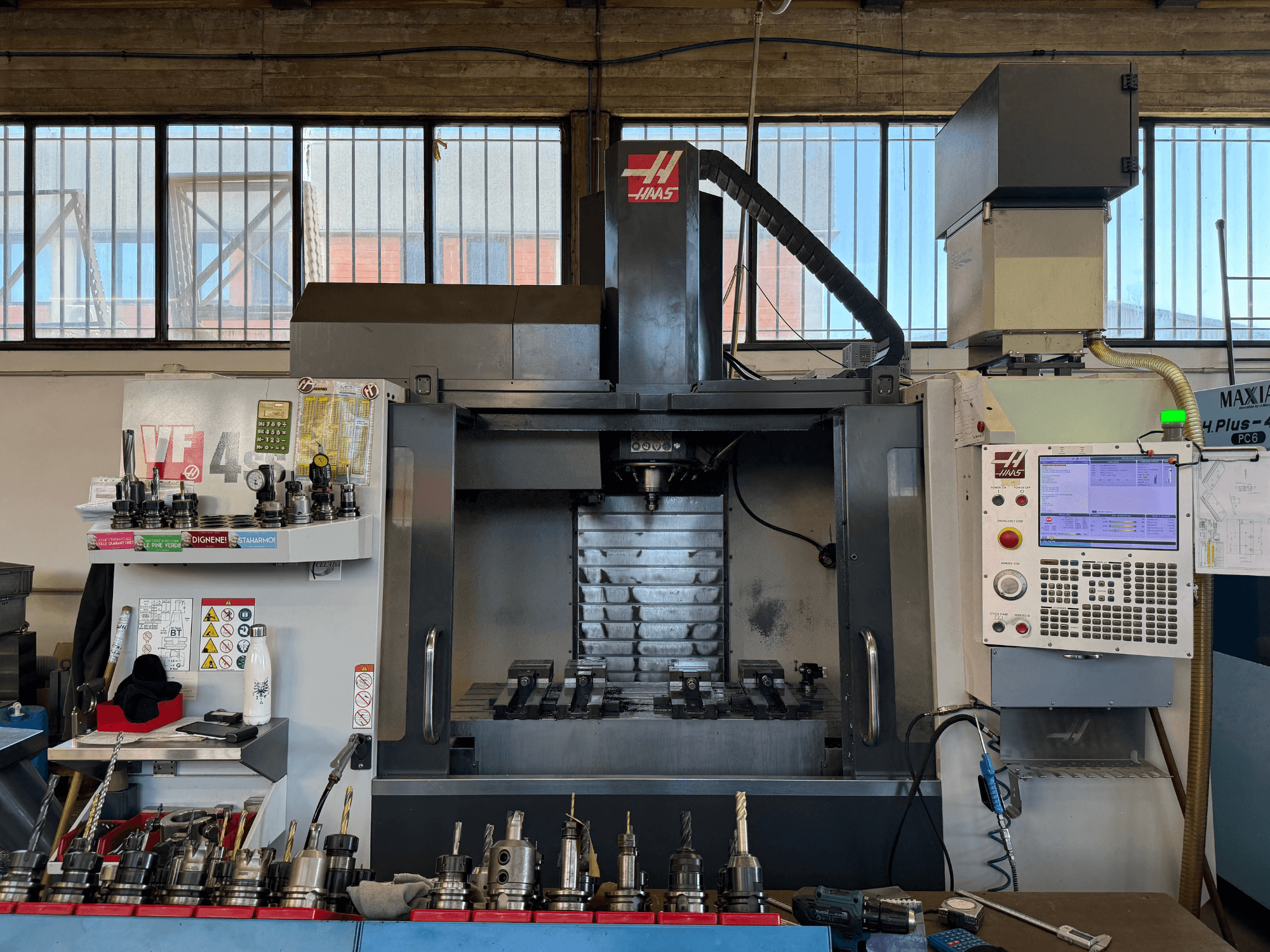 HAAS VF-4SS függőleges megmunkáló központ, elölnézet, a vezérlőpanellel, a szerszámtartókkal és a látható orsóterülettel.
