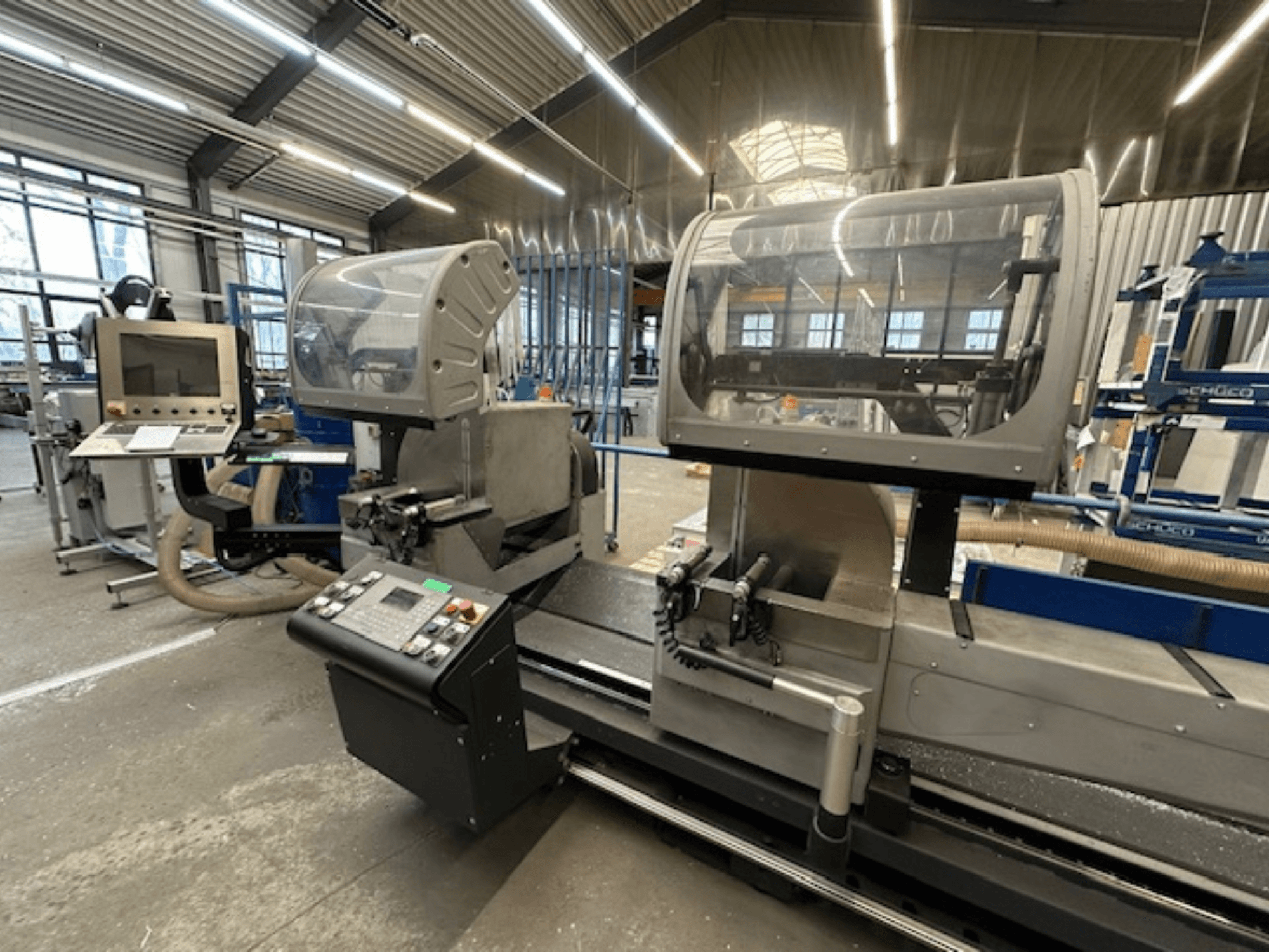 SCHÜCO PDG E CUT fém körfűrész, elölnézet, a kezelőpanel, a védőburkolatok és a vágási terület műhelyben.