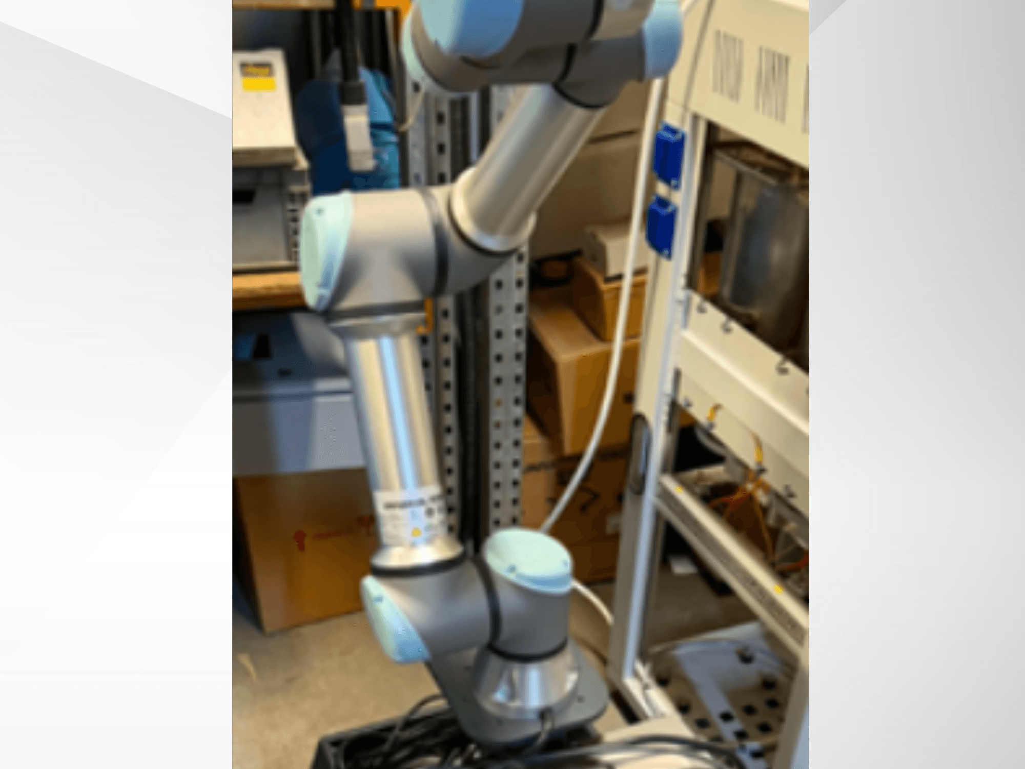 Az Universal Robots UR5e robotkar oldalról nézve: láthatók a csuklós ízületek, a könnyű szerkezet és a vezérlőkábelek.