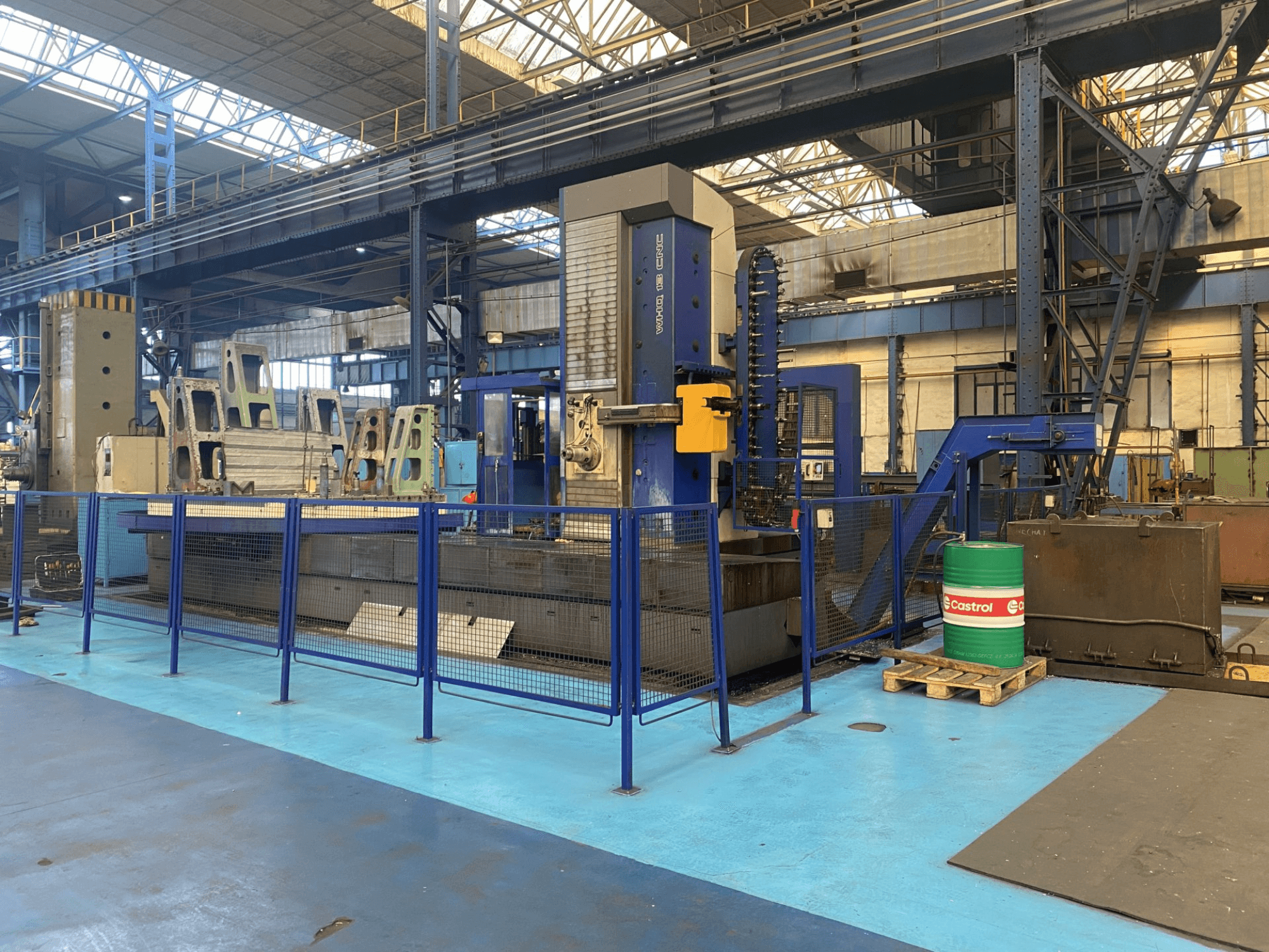 TOS WHQ 13 CNC fúrógép egy műhelyben, elölnézetben, kék keret és a körülötte lévő biztonsági kerítés látható.