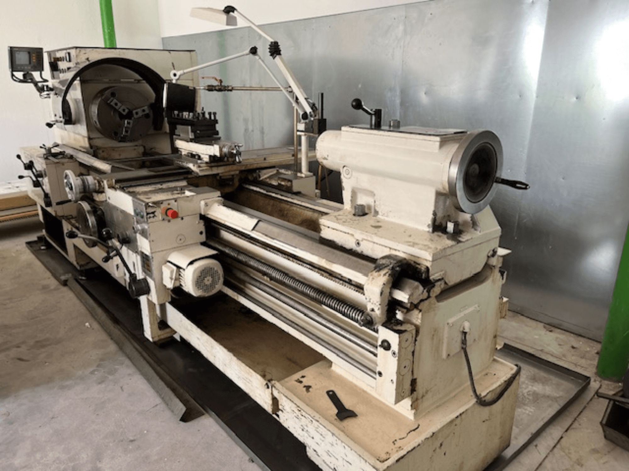 Vintage fém esztergagép vezérlőpanellel és szerszámokkal, oldalnézetben, működési elemek és fémfelület látható.