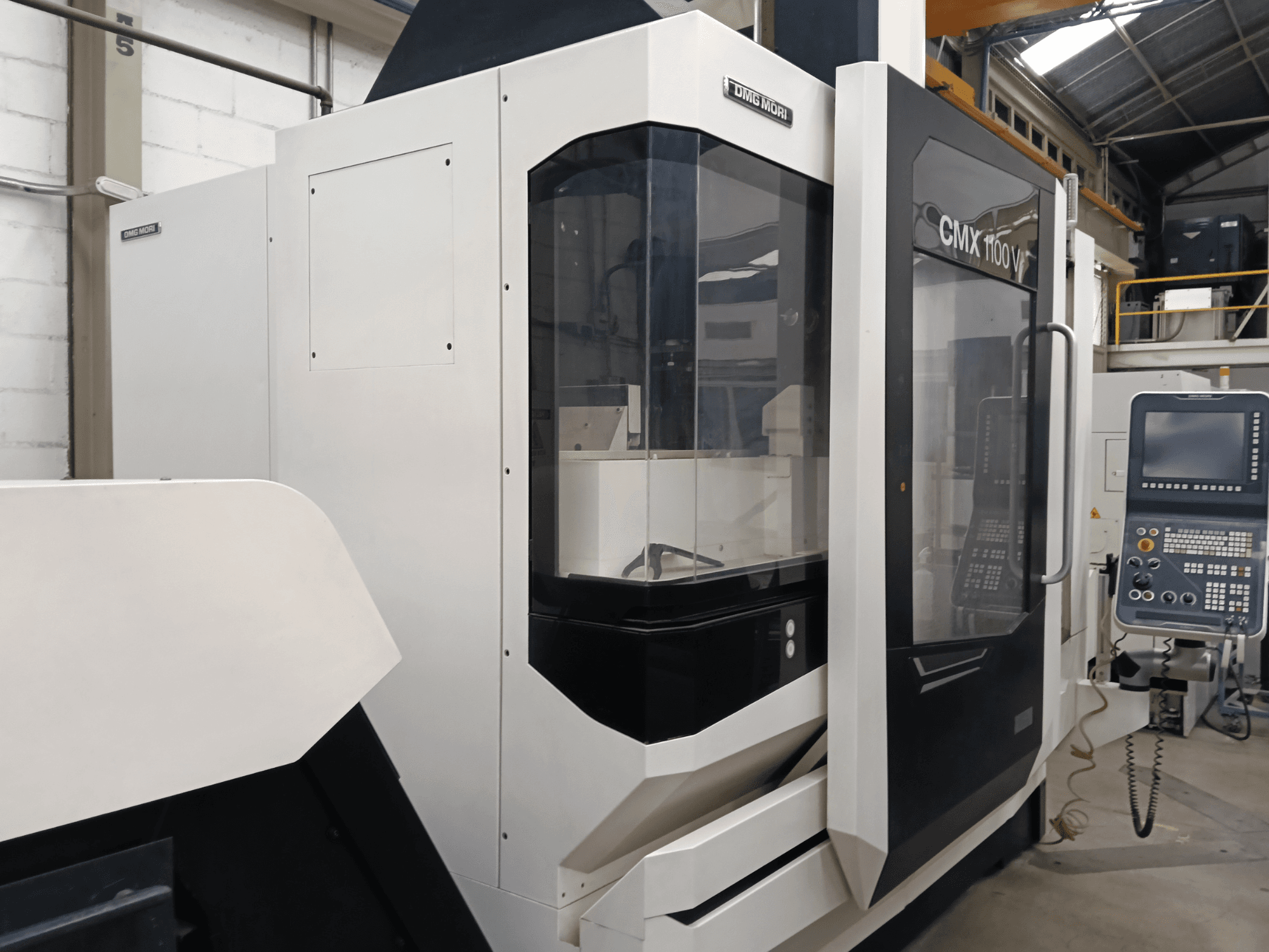 DMG MORI MORI CMX 1100 V függőleges megmunkáló központ, elölnézet, a vezérlőpanellel és az üvegburkolattal.