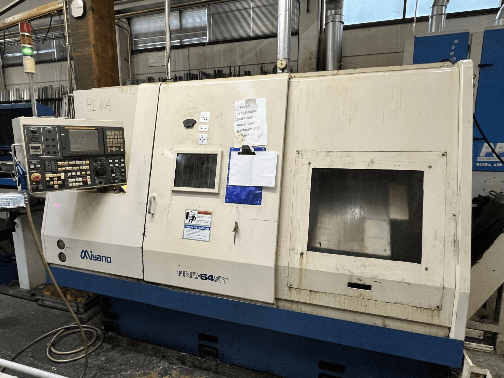 Miyano BNE-64SY CNC esztergagép, előlnézet, gombokkal ellátott kezelőpanel, LCD kijelző és karbantartási matricák a szekrényen.