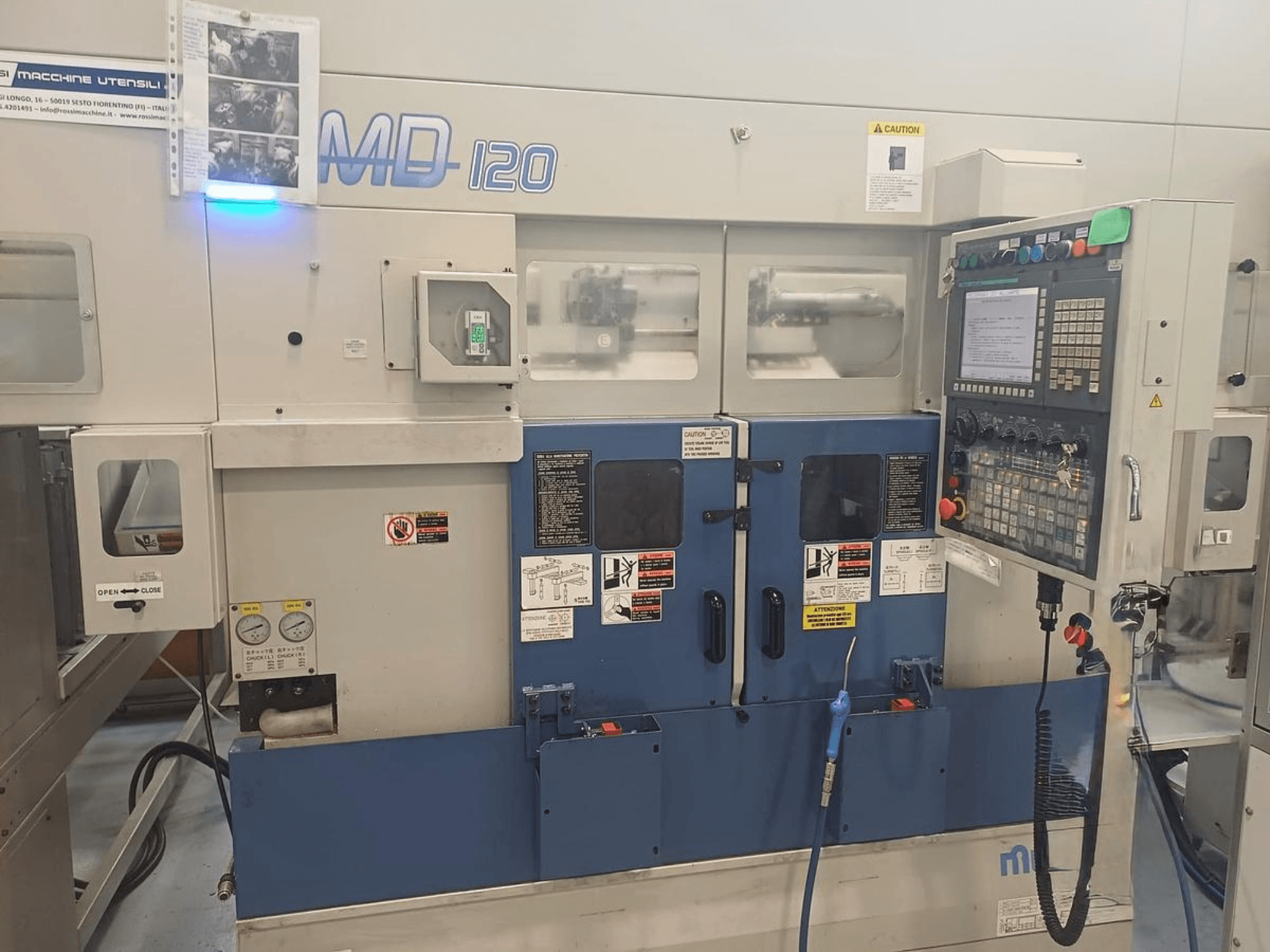 Vízszintes esztergagép MURATEC MD 120, elölnézetben a kezelőpanel, az ajtó és a nyomásmérők.