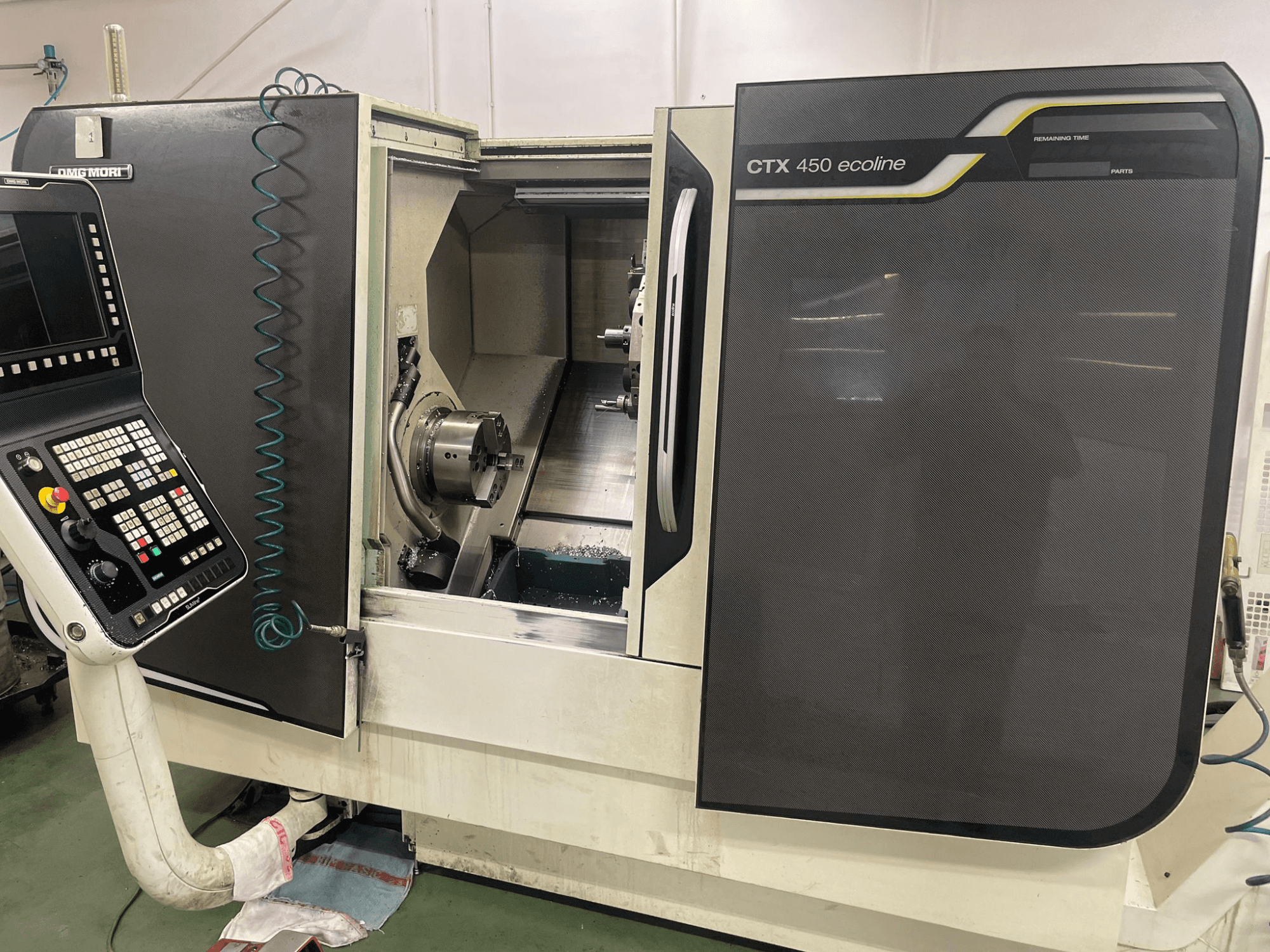 DMG MORI CTX 450 ecoline CNC-gép oldalnézetben, a vezérlőpanel, a tokmány és a megmunkálási terület látható.