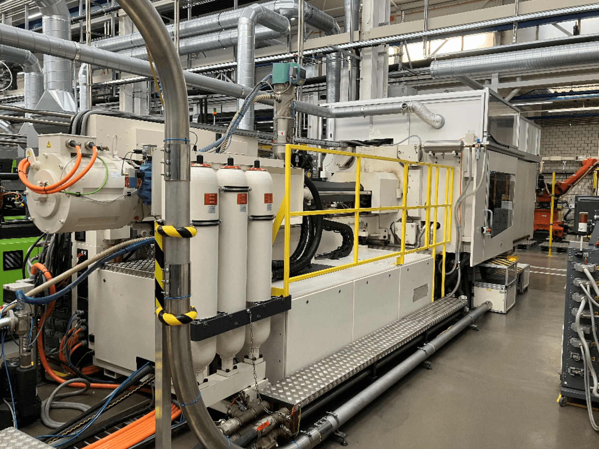 Ipari gép fehér és szürke burkolattal, több tömlővel és szűrőtartállyal; oldalnézetben a működési beállítások bemutatása.