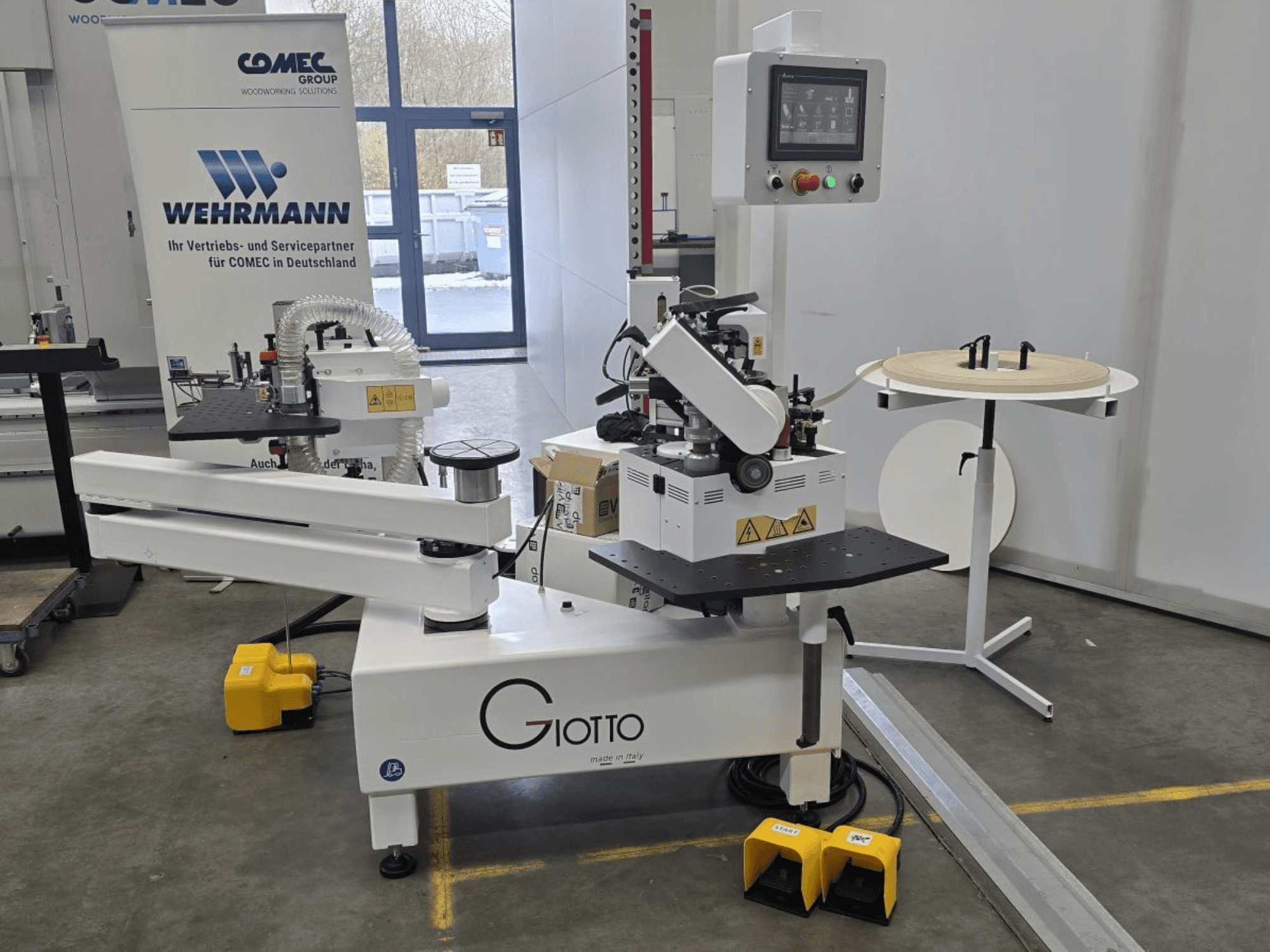 Giotto fafeldolgozó gép vezérlőpanellel, oldalnézetben, lábpedálokkal és forgó munkafelülettel.