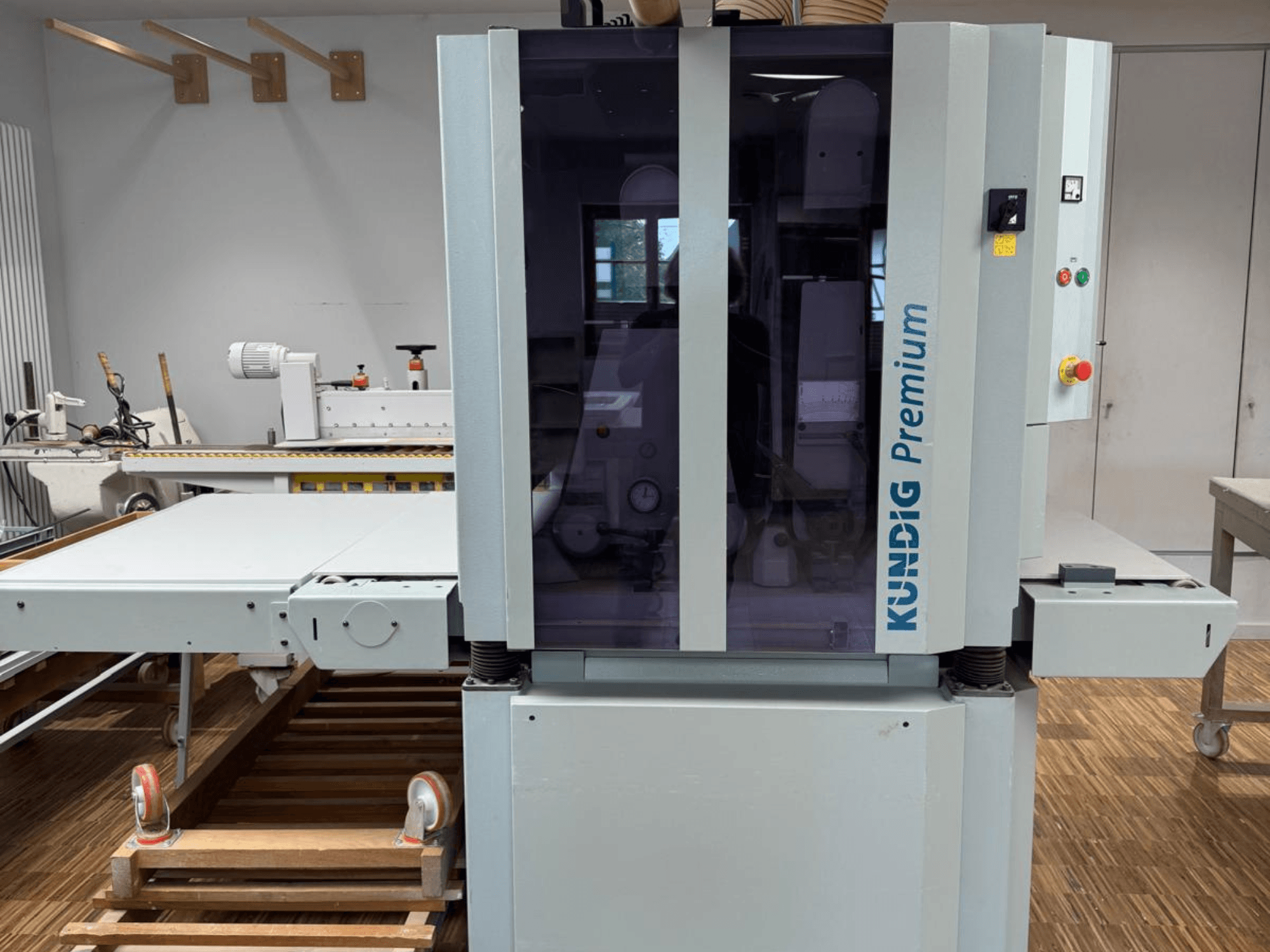 Kundig Premium 2-1100-RP szalagcsiszoló elölnézetben, kezelőpanel és nagy üvegburkolat a láthatóság érdekében.