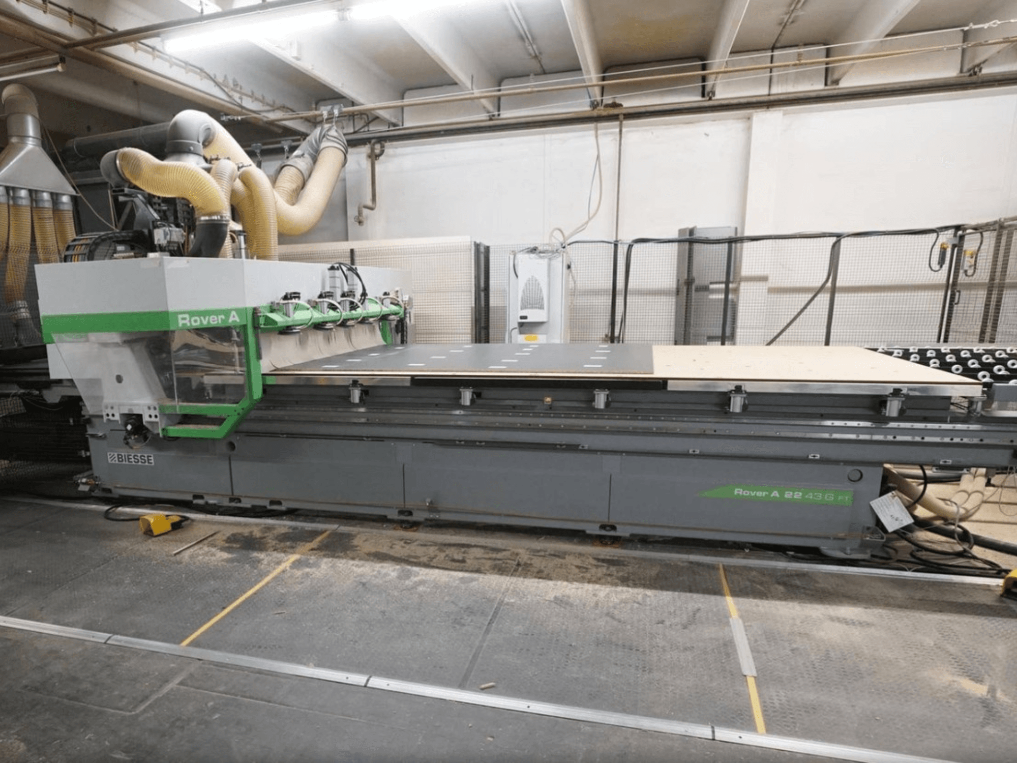 A BIESSE Rover A FT 2243 CNC faipari megmunkáló központ – elölnézet – nagy munkapaddal és szerszámrögzítő rendszerrel rendelkezik.